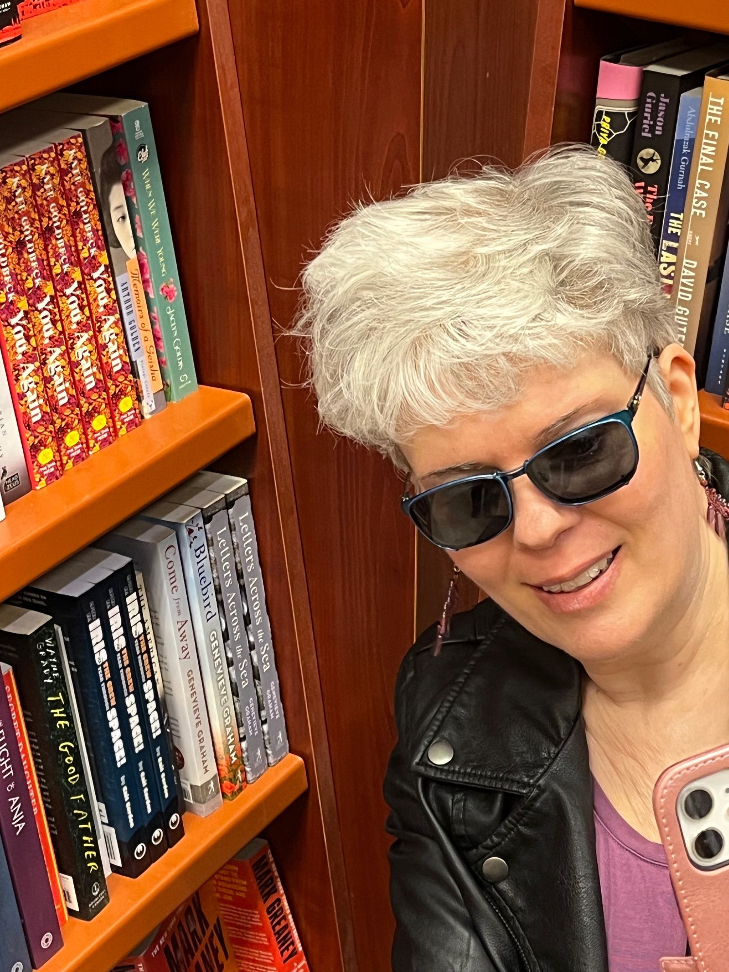 Bruce is taking a photo of me taking a selfie by my books on the shelf