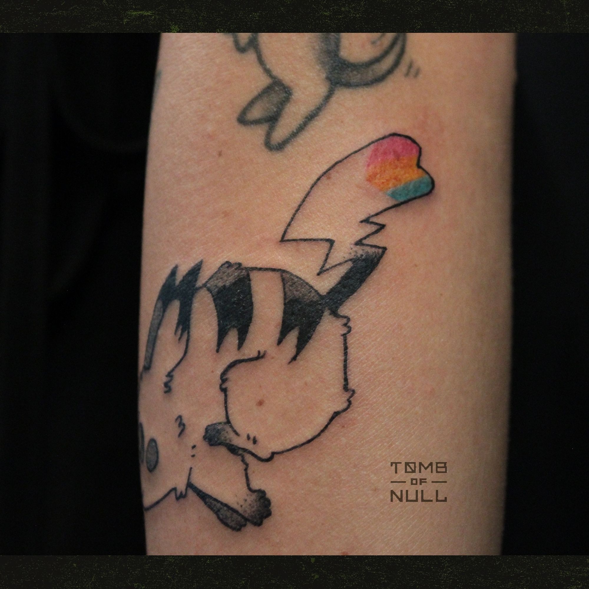 A fresh tattoo of a dashing pikachu done on pale skin. Her tail is heart shape, and bares the pansexual flag colors.