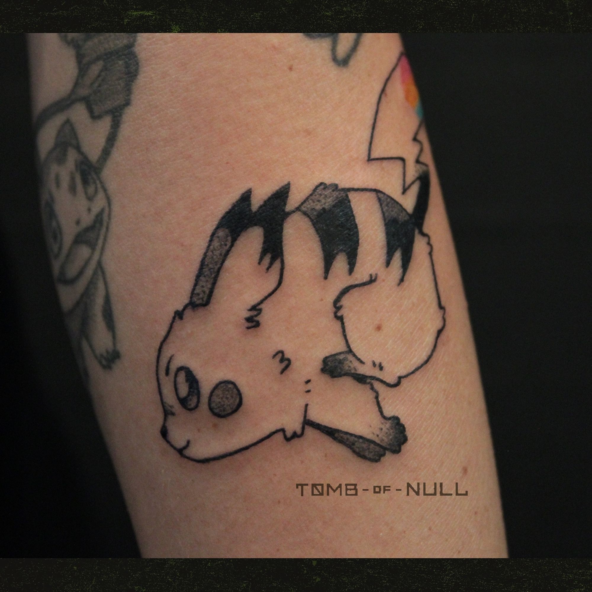 A fresh tattoo of a dashing pikachu done on pale skin. Her tail is heart shape, and bares the pansexual flag colors.