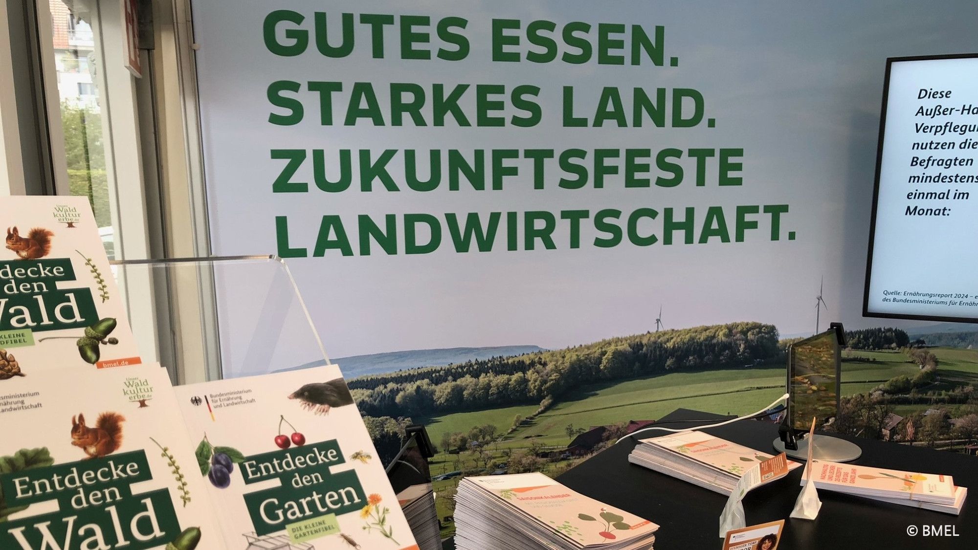 Stand des BMEL: Im Vordergrund Broschüren, im Hintergrund steht: Gutes Essen. Starkes Land. Zukunftsfeste Landwirtschaft.