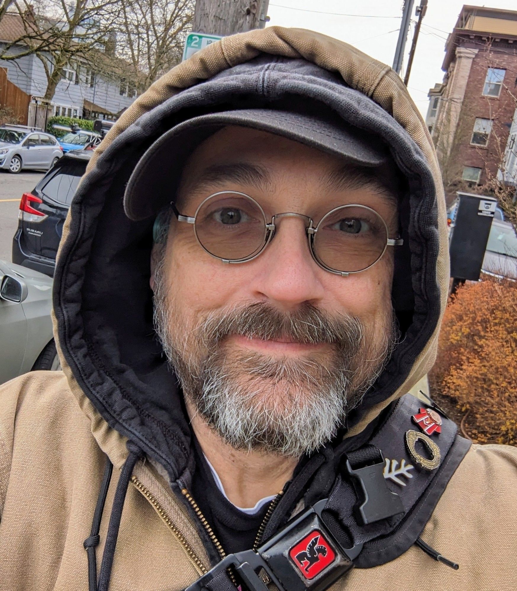 Selfie of me, a middle-aged white guy, on the sidewalk, bundled under a hoodie and jacket.