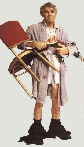 image of Steve Martin from the movie The Jerk, holding a chair, a remote control, and various other bric-a-brac. Also, his pants are down around his ankles.