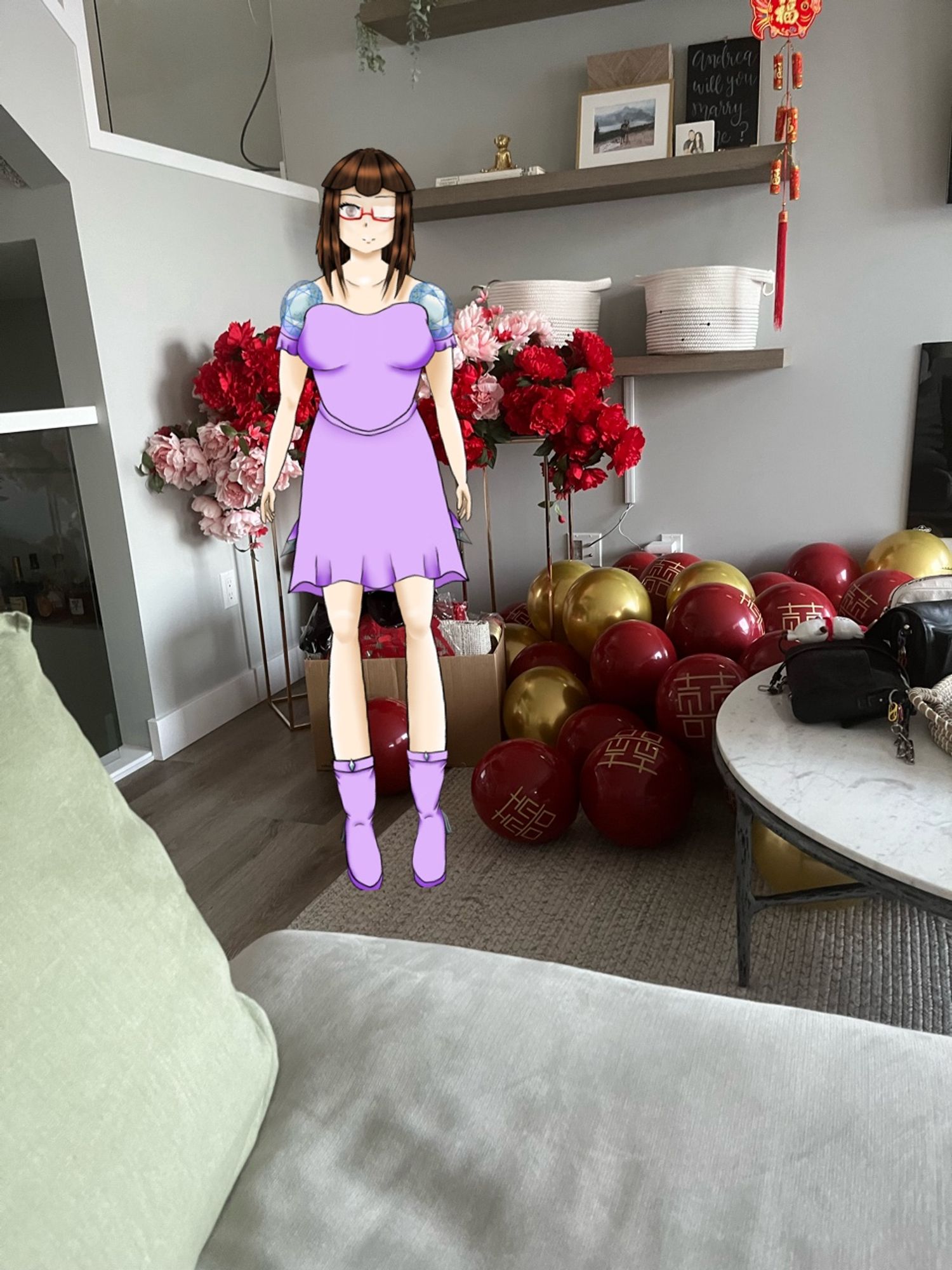 This is a photo of Crystal’s model infront of many balloons that are coloured red and gold and flowers that are white with red tips and completely red.