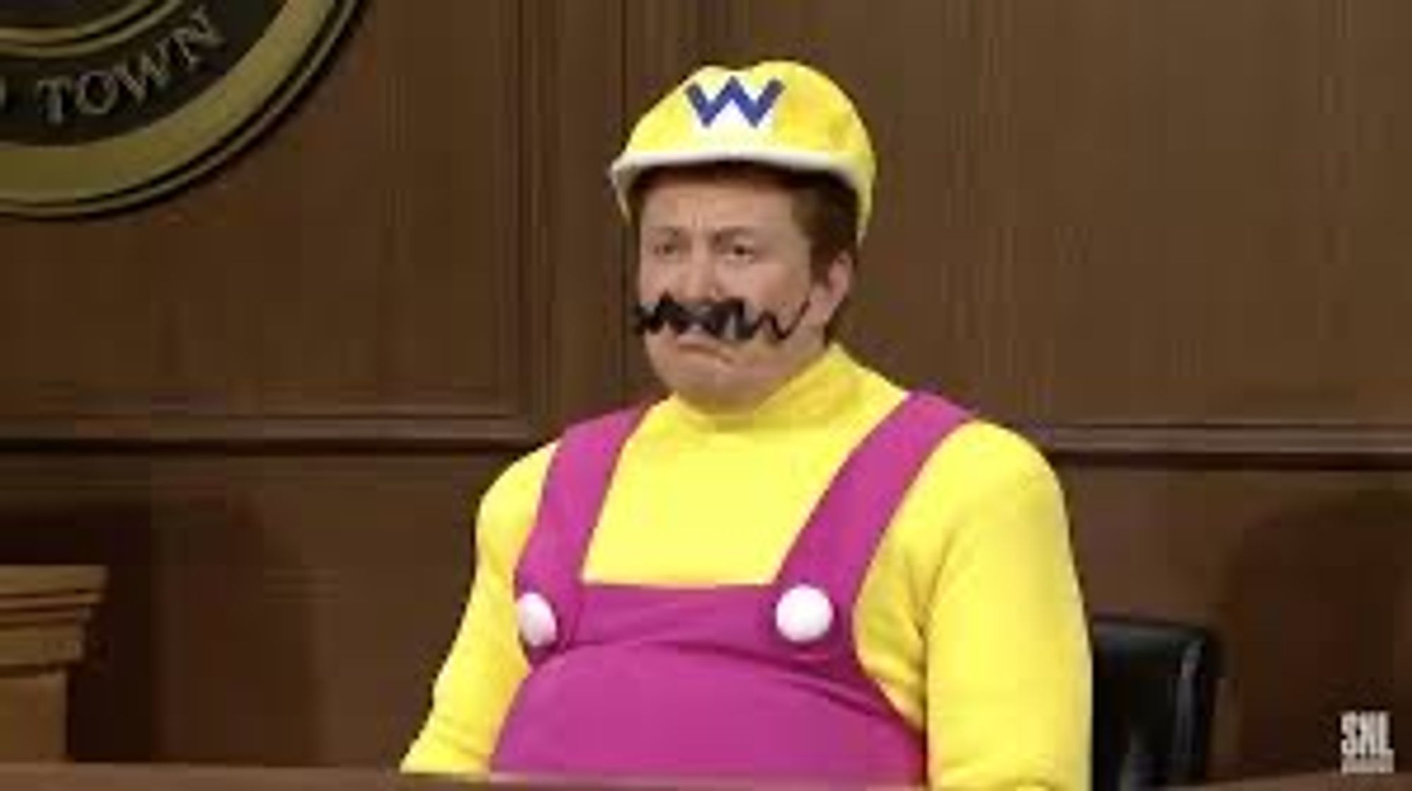 Elon Musk in Wario outfit including fake mustache.