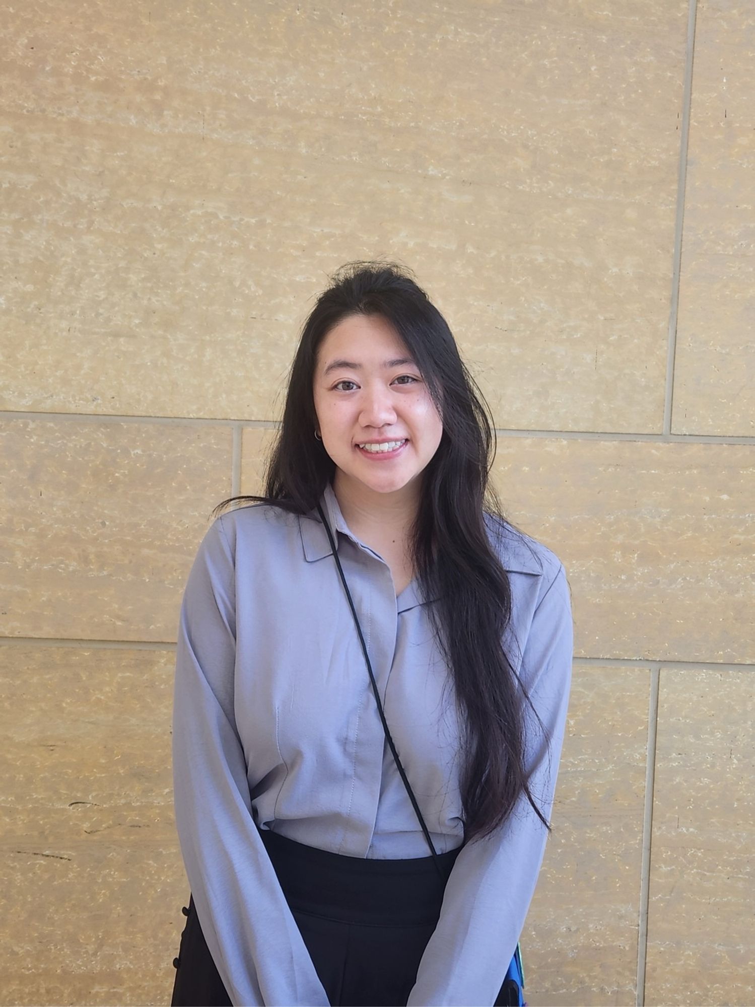 Dominique Pham posing for a photo against a wall after winning an award from the BSA Ecophys section at Botany 2024