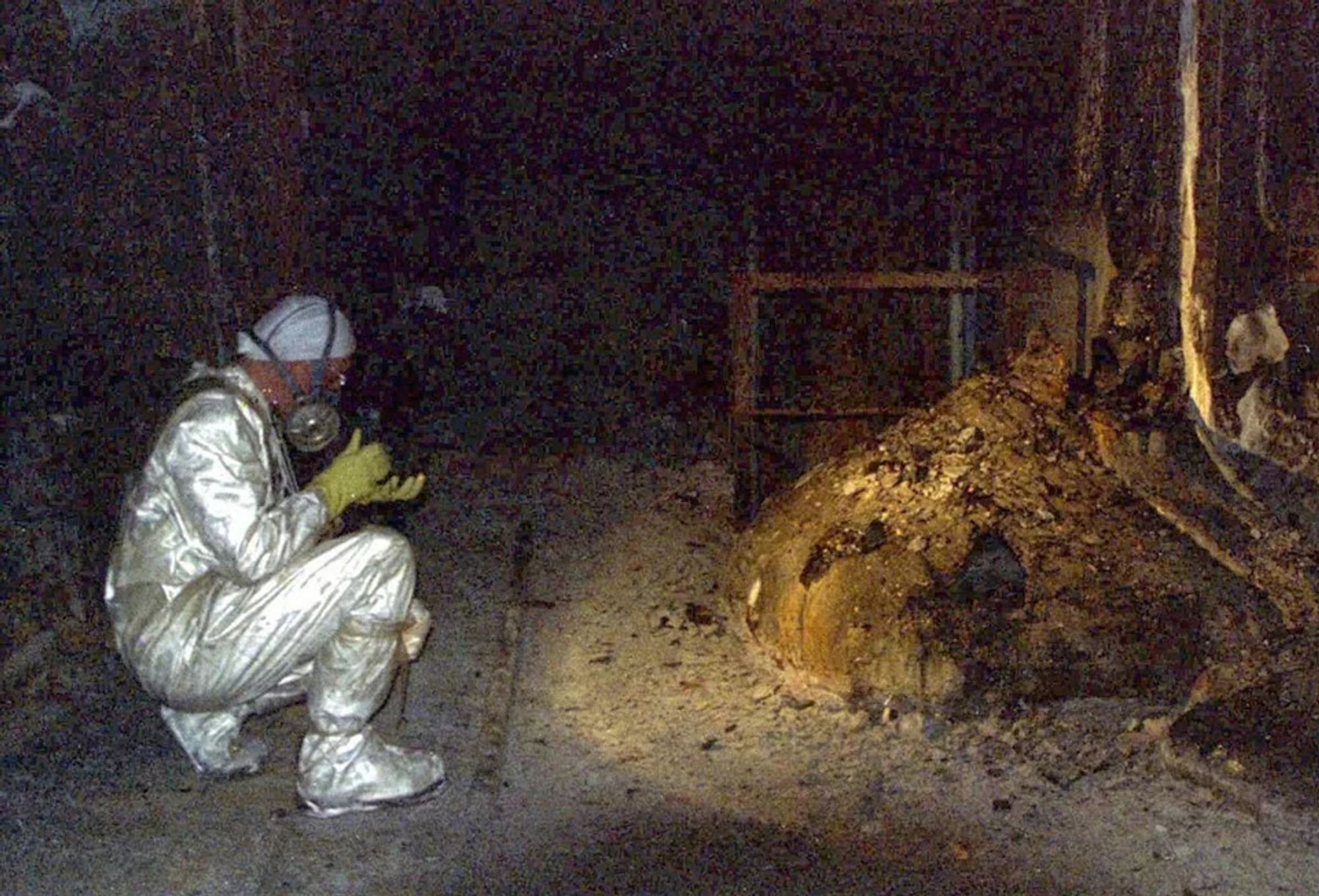 Artur Korneyev crouched next to the Elephant's Foot, a mass of radioactive material resulting from the components of Chernobyl's core melting together. (1996)