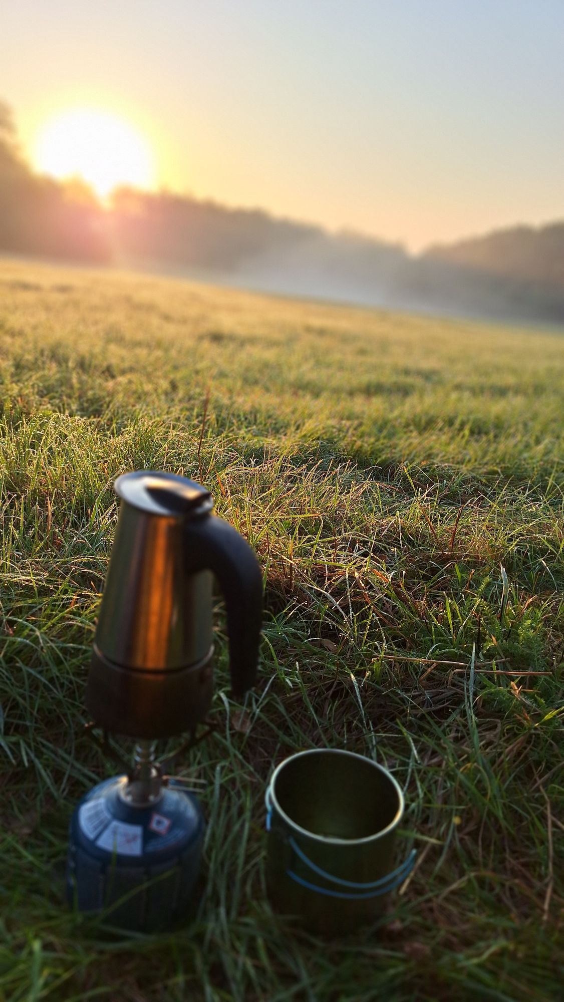 Outdoor coffee set on meadow covered by dew