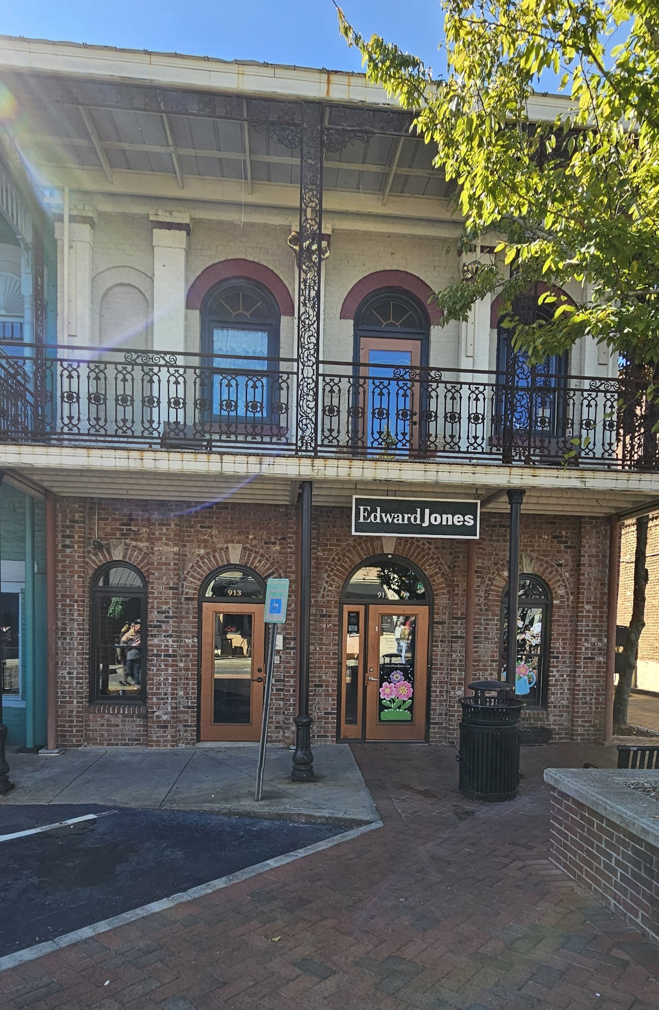 Brick building with a balcony. A sign saying Edward Jones hangs off the balcony