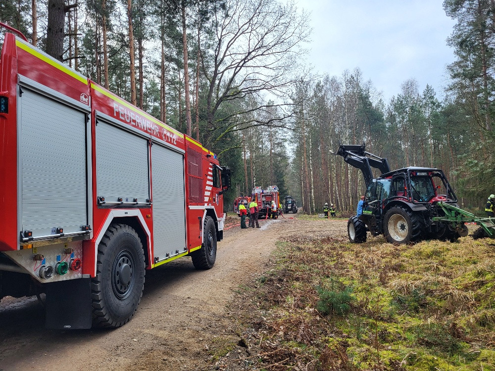 eine Gruppe Feuerwehrautos auf einem Schotterweg