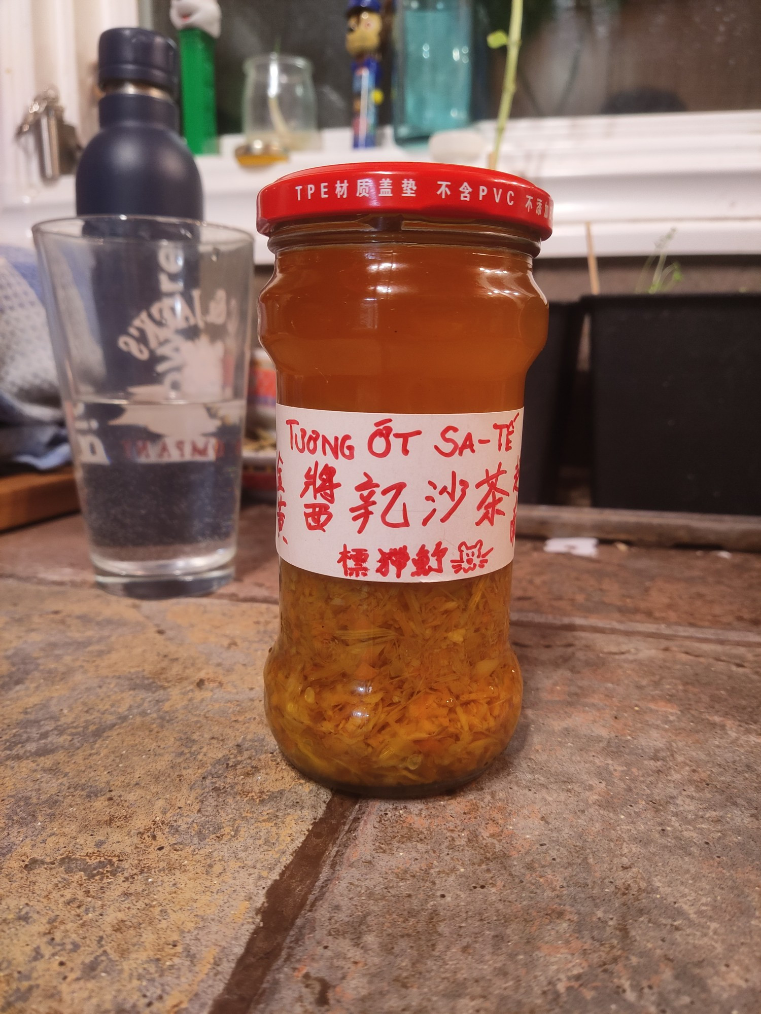 A jar of (Otter Brand) Sa Tế sauce made with Scotch Bonnet chilies