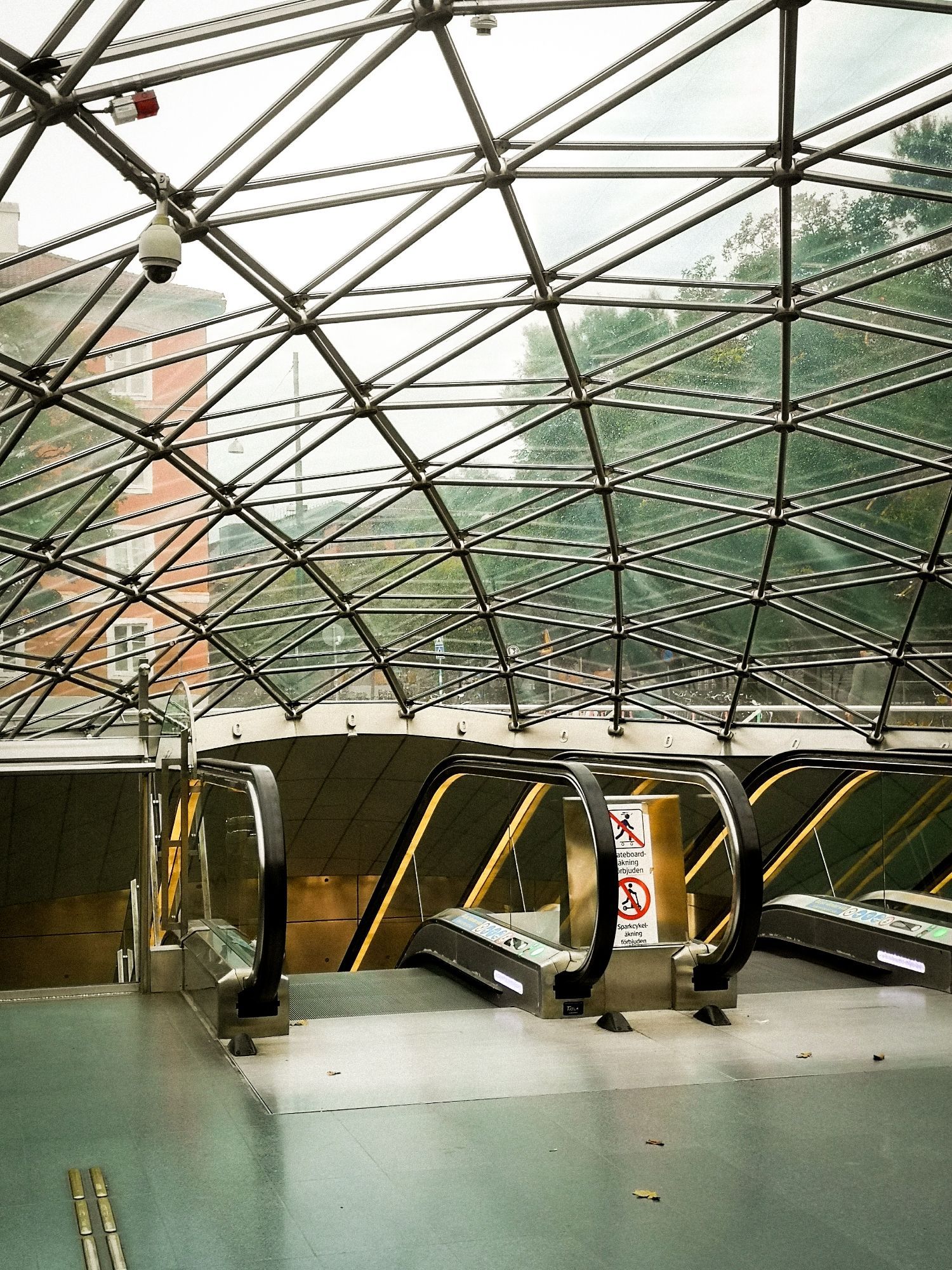 Glaskuppel Eingang Bahnhof von Innen. Zwei Rolltreppen zu sehen nach unten.