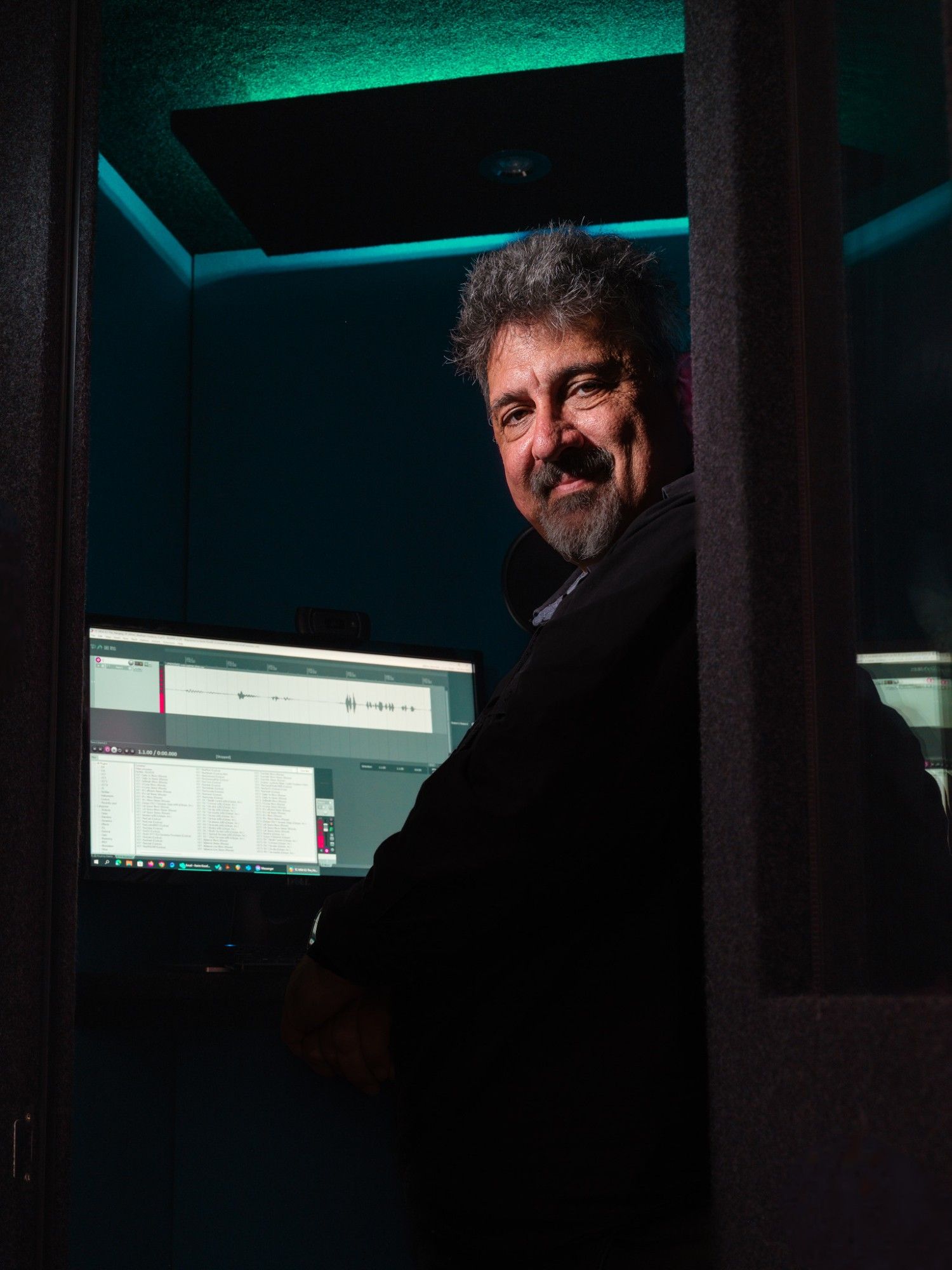 Karim standing in his recording booth