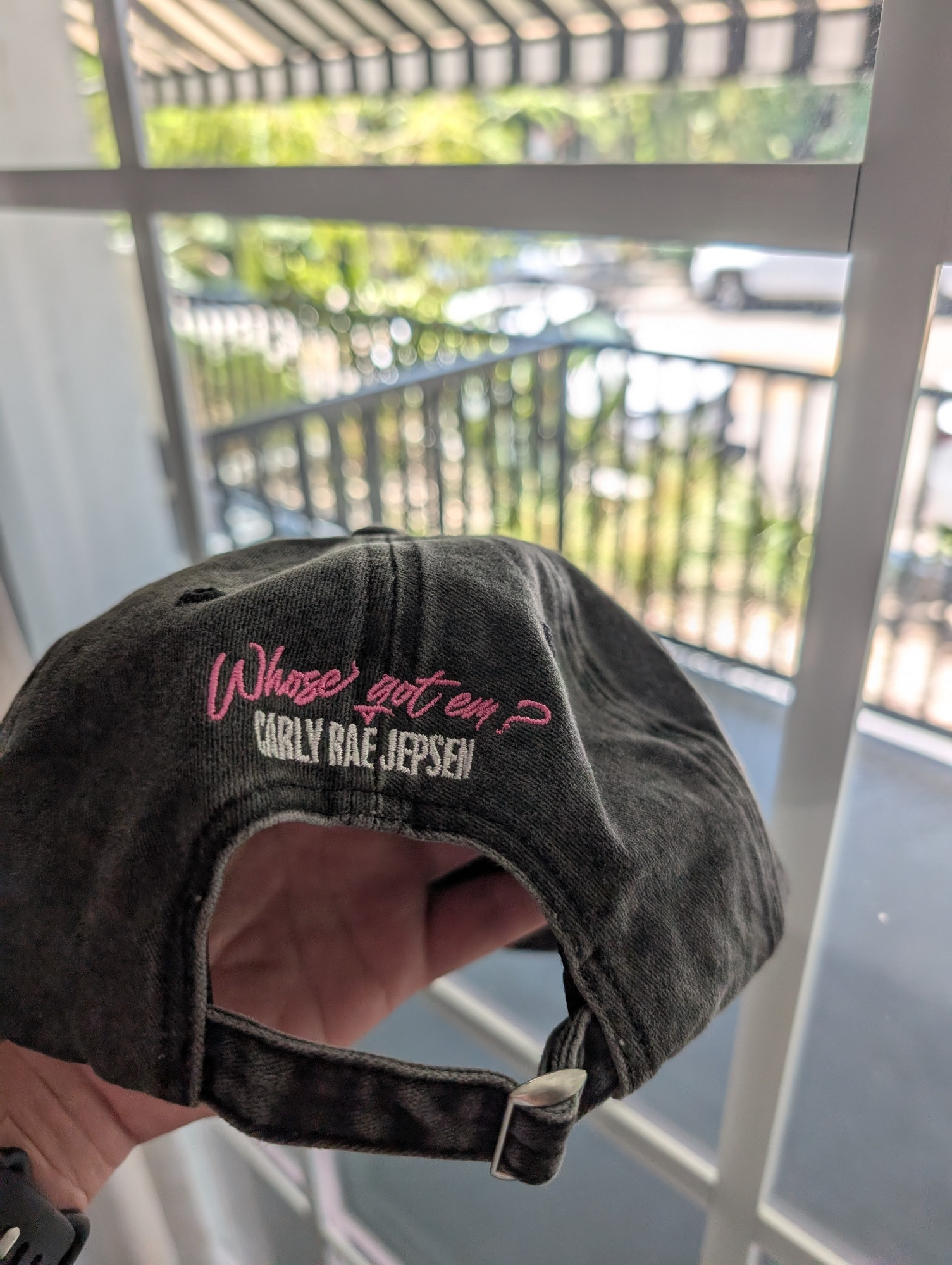 Back of the hat. "Whose got em?" is embroidered in pink and "CARLY RAE JEPSEN" is embroidered in white below.
