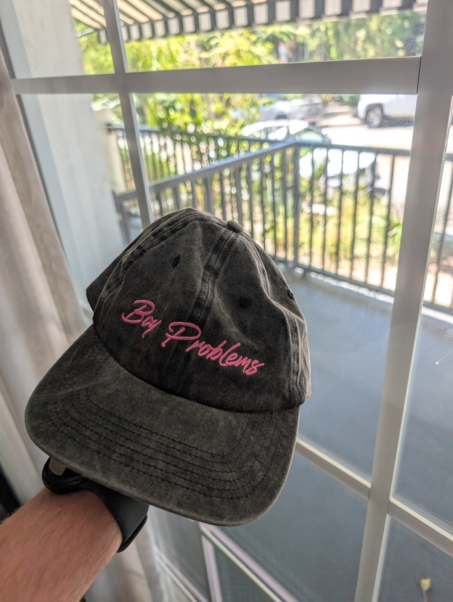 Front of a distressed gray hat. "Boy Problems" is embroidered in pink script.