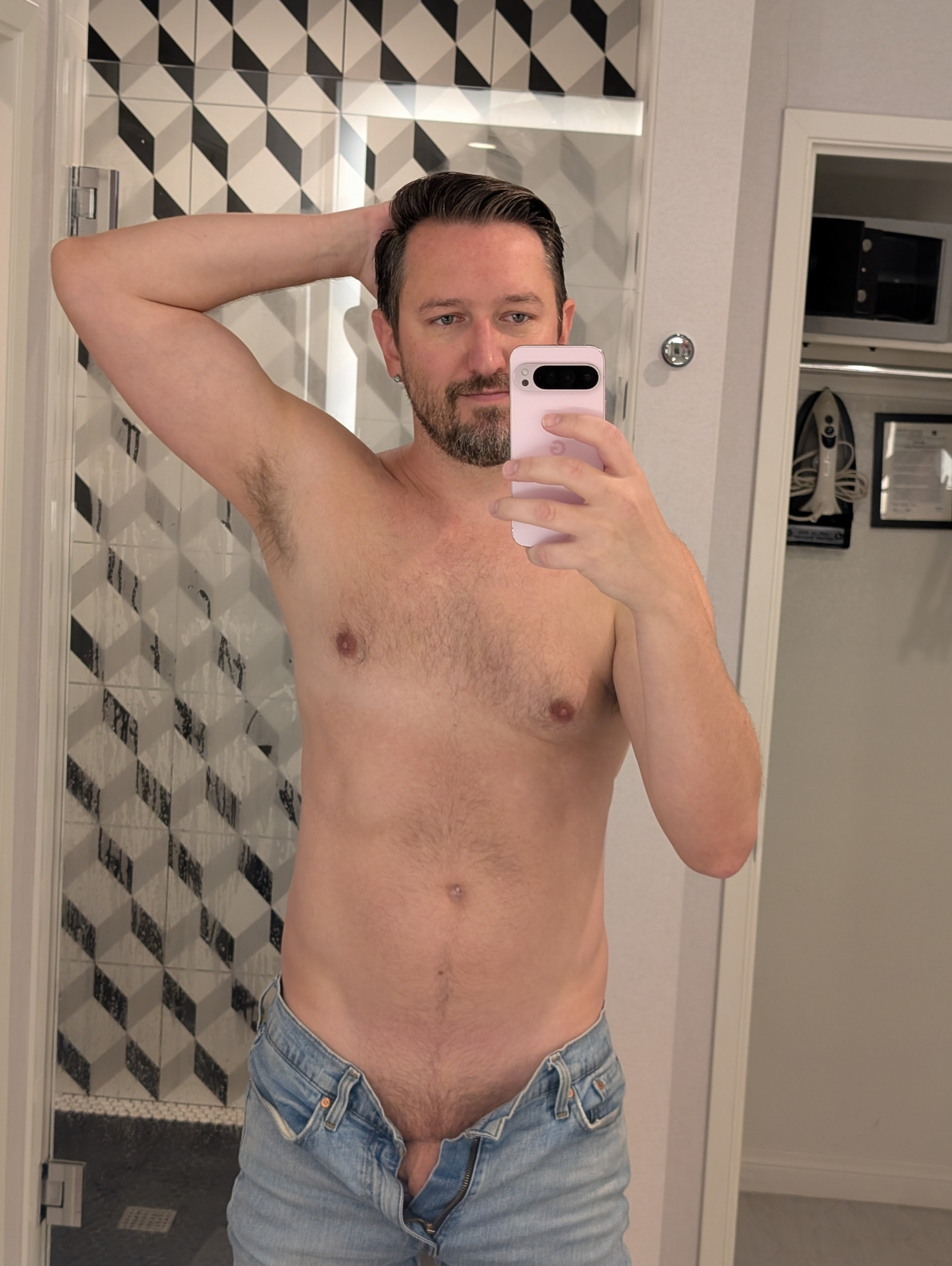 In the bathroom with one arm up showing pit and jeans unbuttoned showing a little base 🍆