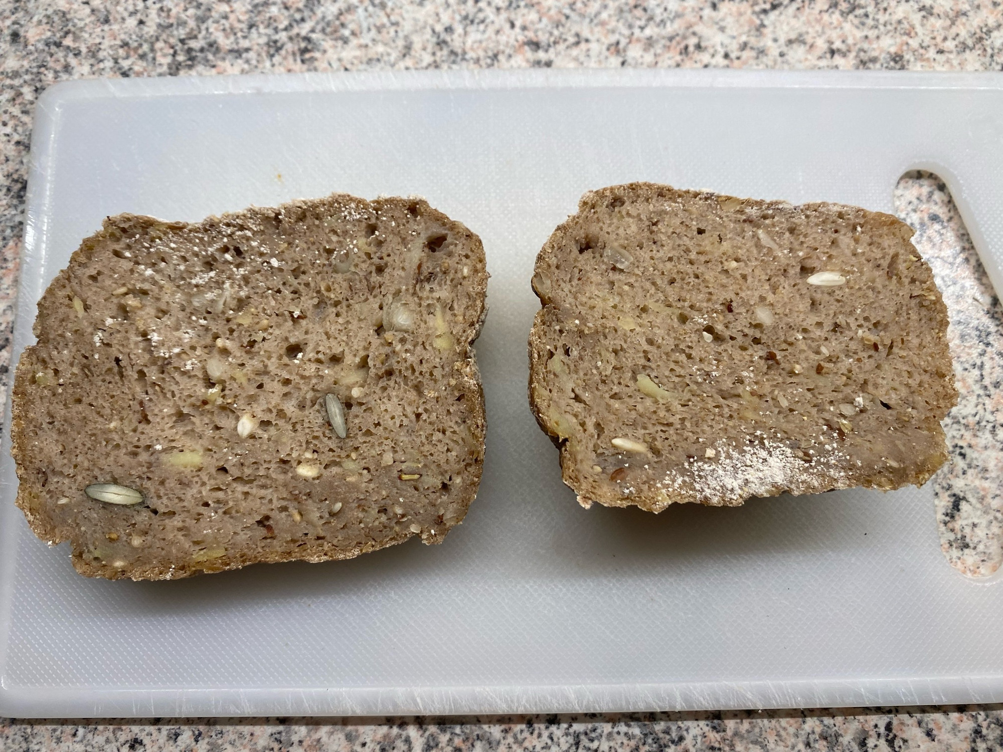 Zwei Scheiben Sauerteigbrot auf einem hellen Frühstücksbrett