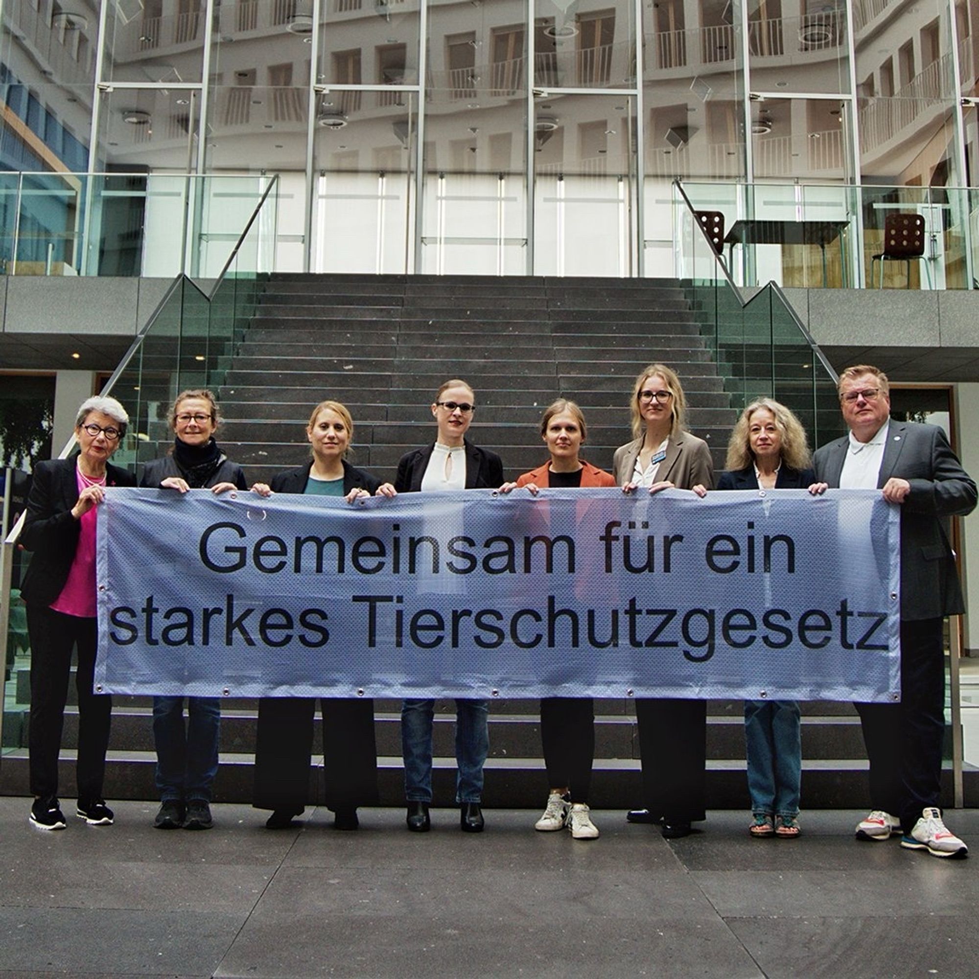 Verbändevertreter halten ein Banner in den Händen mit der Aufschrift: Gemeinsam für ein starkes Tierschutzgesetz