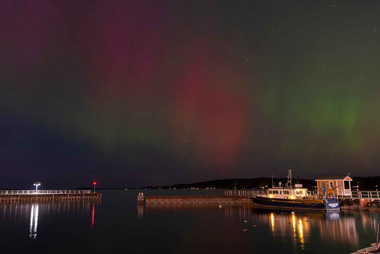 An image of the aurora over Grand Traverse Bay, West Arm, in Traverse City, Michigan. A research vessel, the Northwestern, is visible in the foreground toward the right side of the frame.