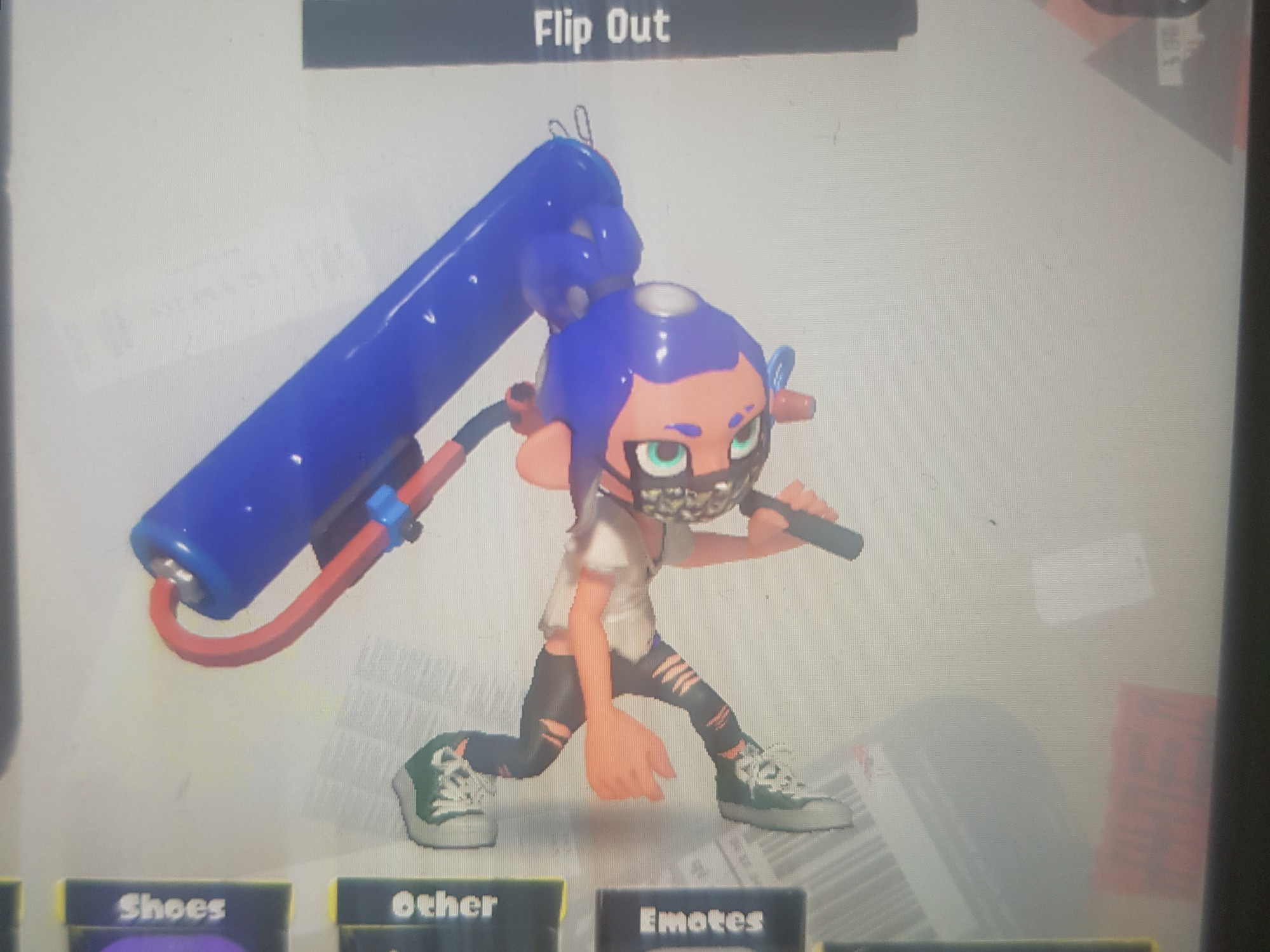 A photo of a (currently dark blue) Oktoling  wearing black ripped pants, Hunter Hi-Tops, Tri-Shred Tee & a Squid Facemask. Thry currently have the Krak-On Plat Roller equipped. 