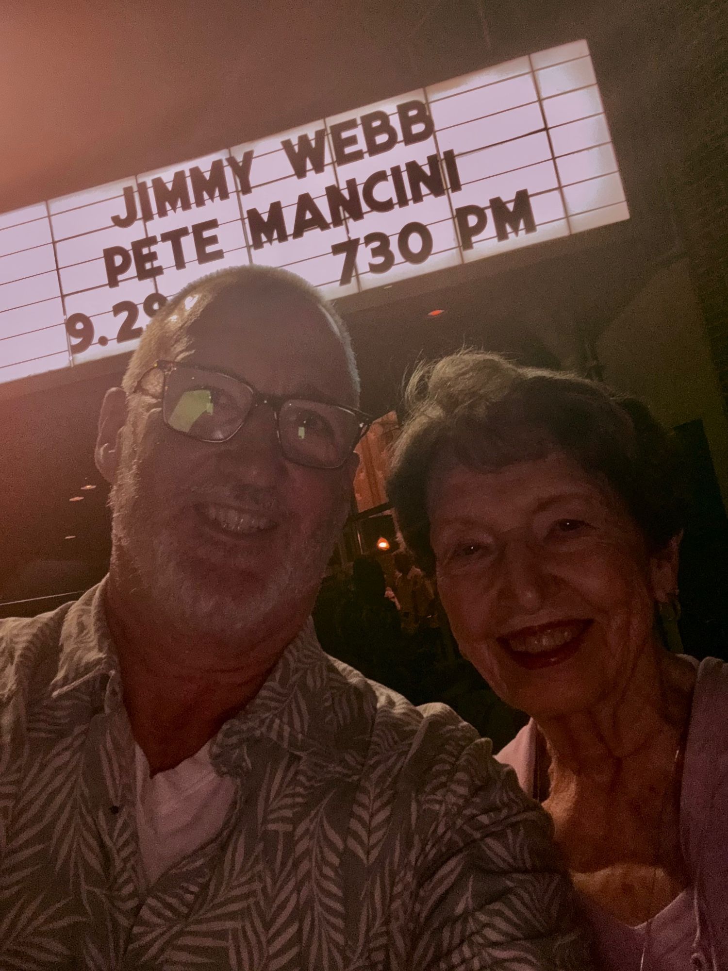 Me and mom backlit af by the marquee reading Jimmy Webb and Pete Mancini