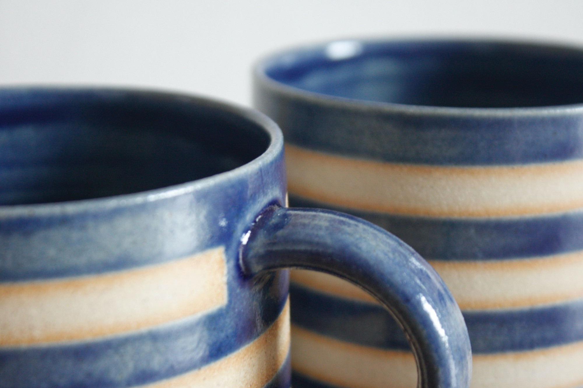 Close up of some blue striped mugs. 