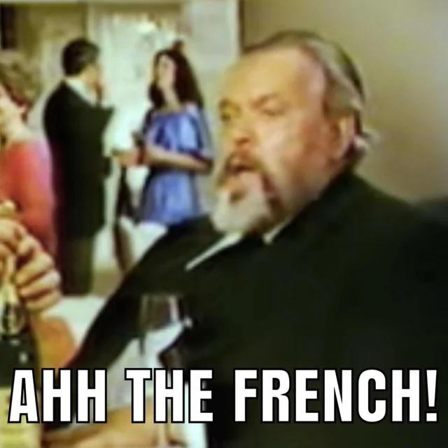 Orson Welles holding wine and saying, “Ahh the French!”