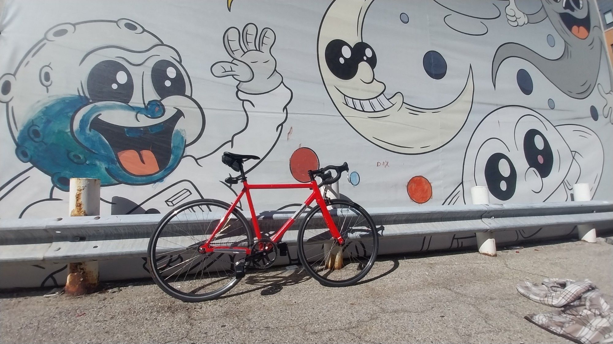 Pink All City Thunderdome Bicycle in front of a mural featuring multiple figures in the "rubberhose / cuphead" style.