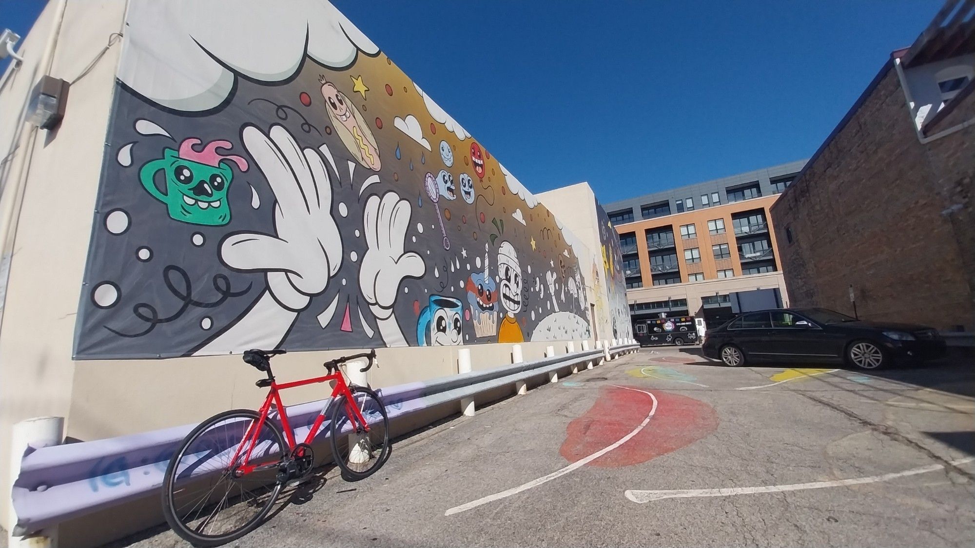 Pink All City Thunderdome Bicycle in front of a mural featuring multiple figures in the "rubberhose / cuphead" style.