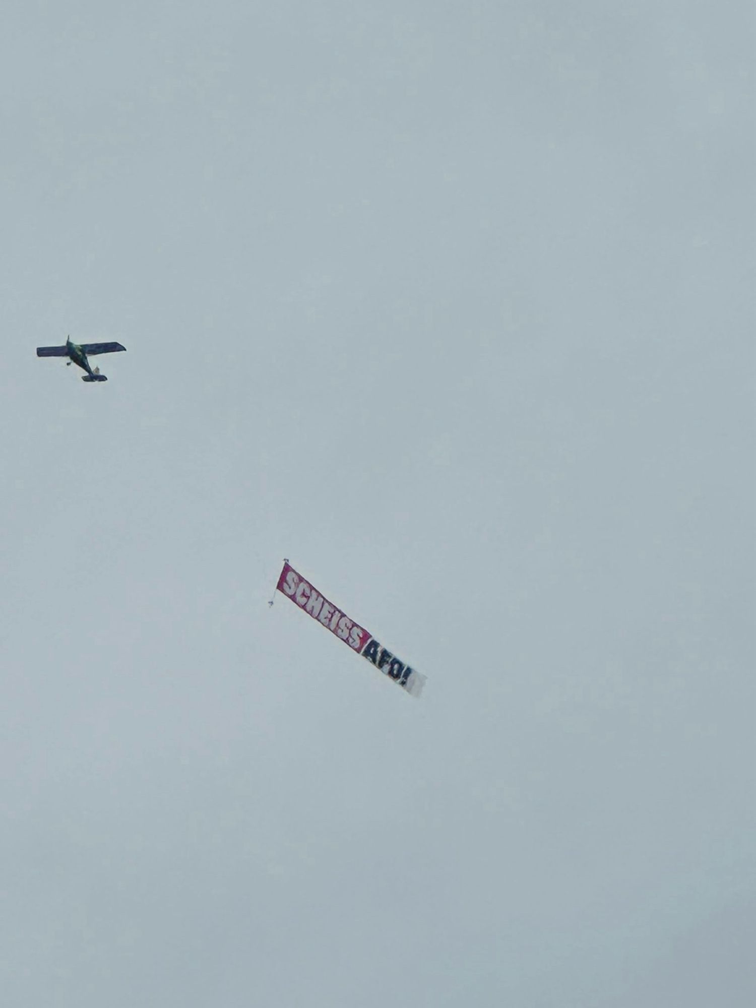 Ein Flugzeug über dem Augustusplatz mit dem Banner: „Scheiss AfD“