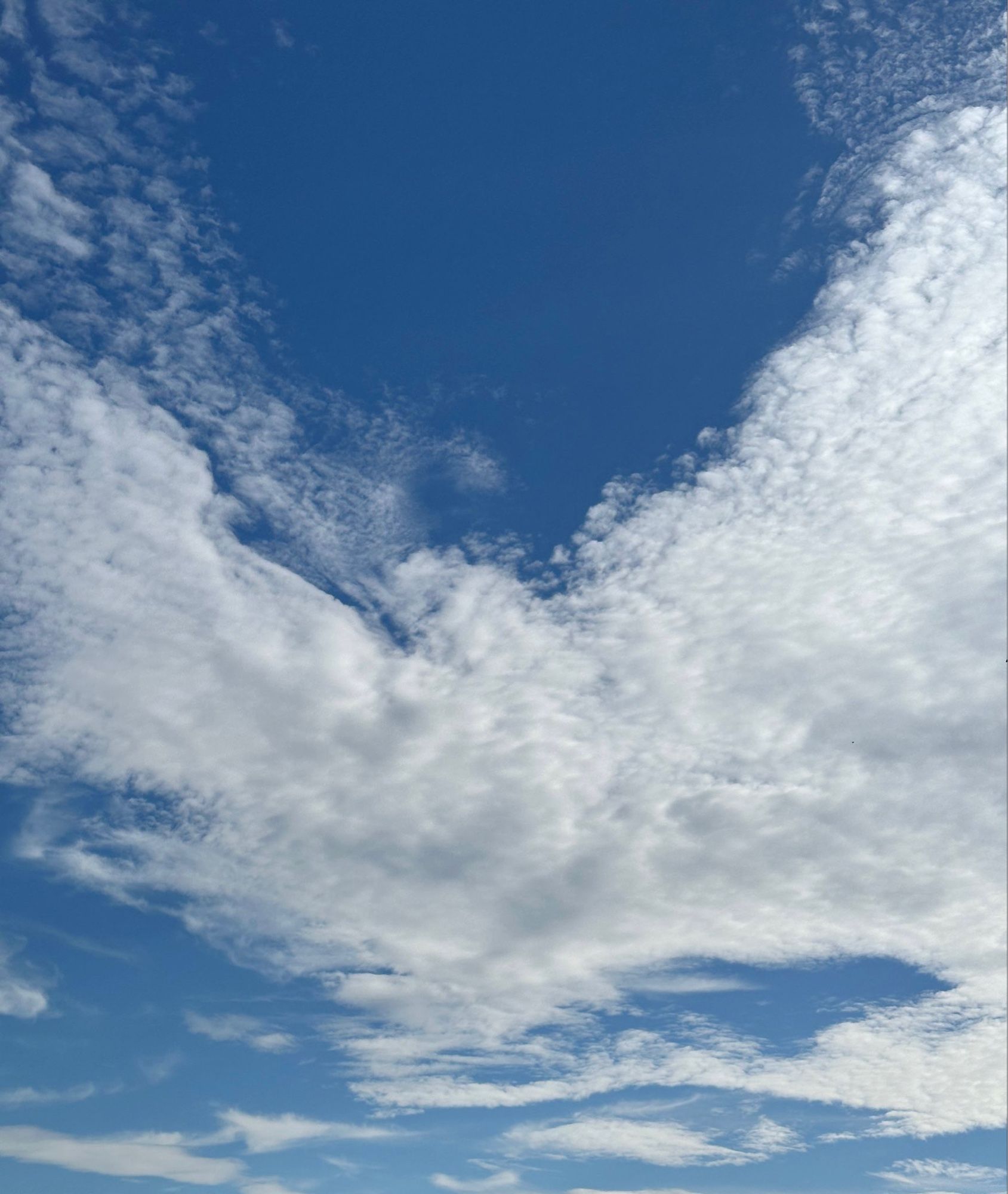 Wolken, die wie ein Engel (oder ein Schmetterling) mit ausgebreiteten Flügeln (Armen) aussehen.