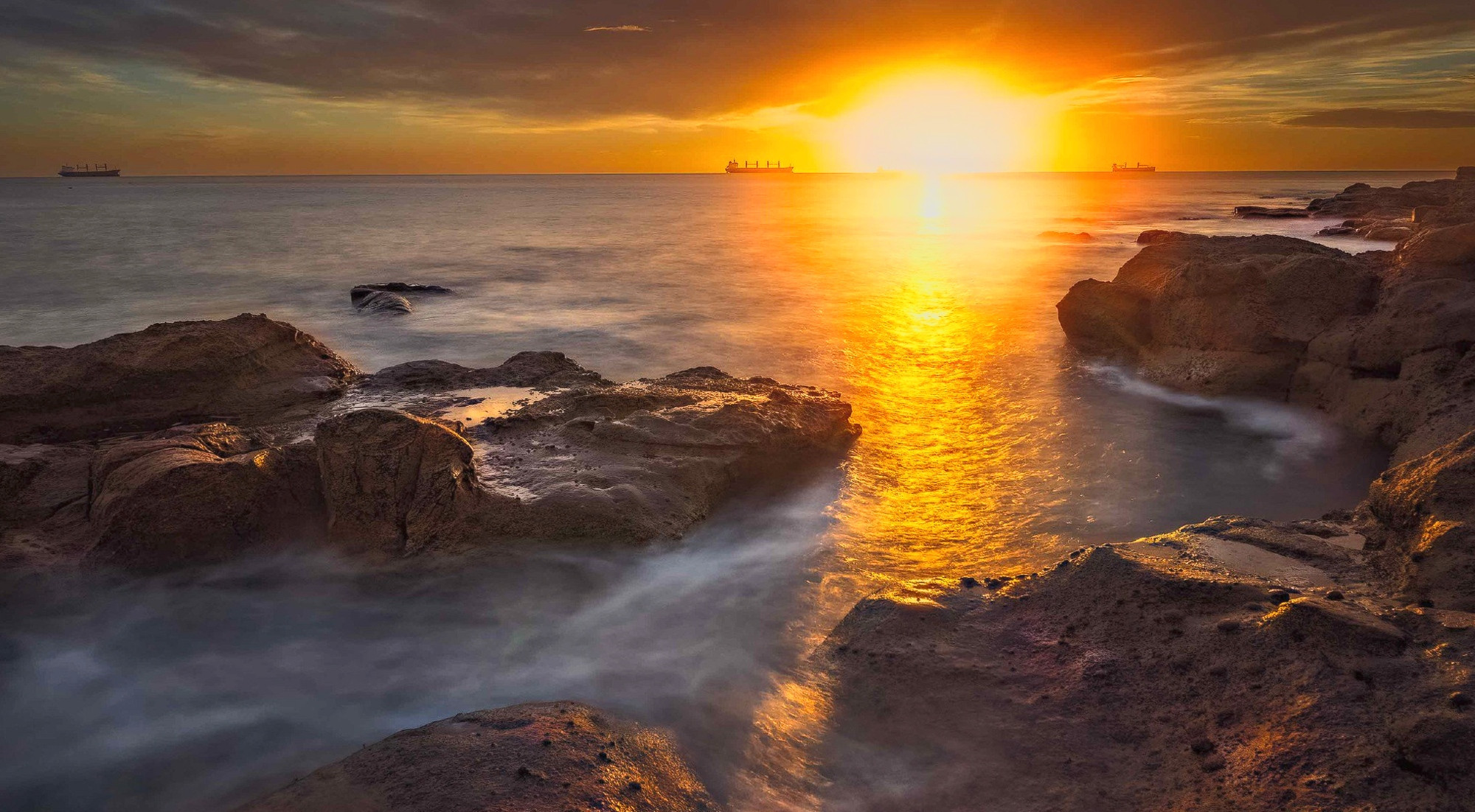 Sunrise on the sea and rocks at Whitley Bay in the UK.