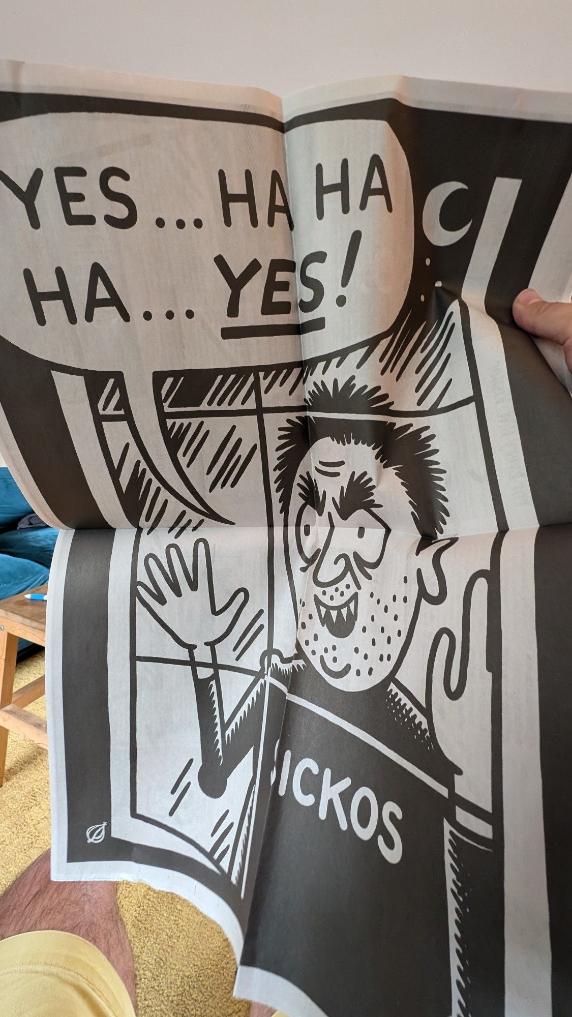 Center pages from the latest issue of The Onion. A man with "Sickos" printed on his shirt peers through a window while exclaiming "Yes ... Ha ha ha ... Yes!"