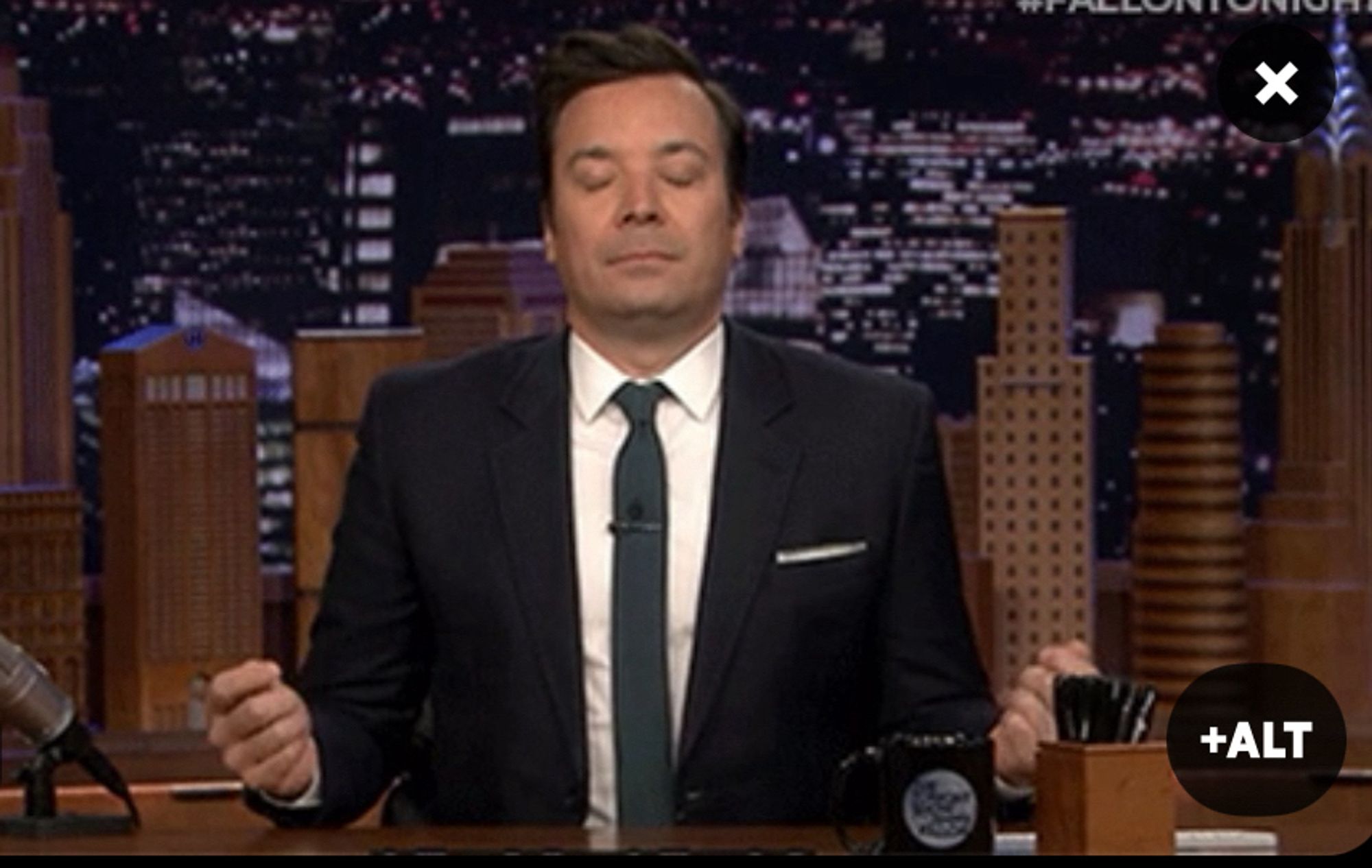 Jimmy Fallon qui respire, les yeux fermés et les bras ouverts (imitant une posture zen)