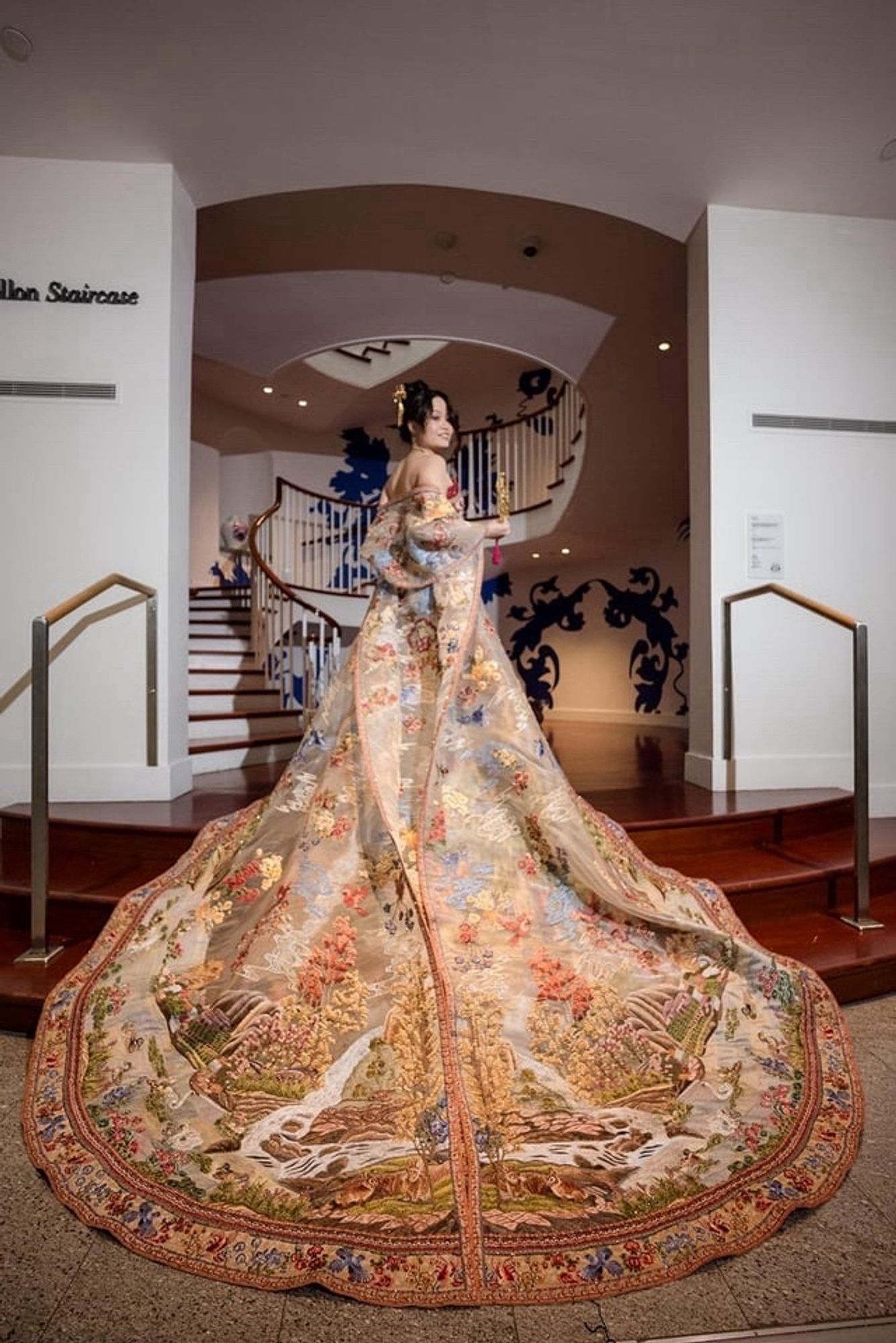 Stunning pic of the back of her gown, embroidery of a mountain scene