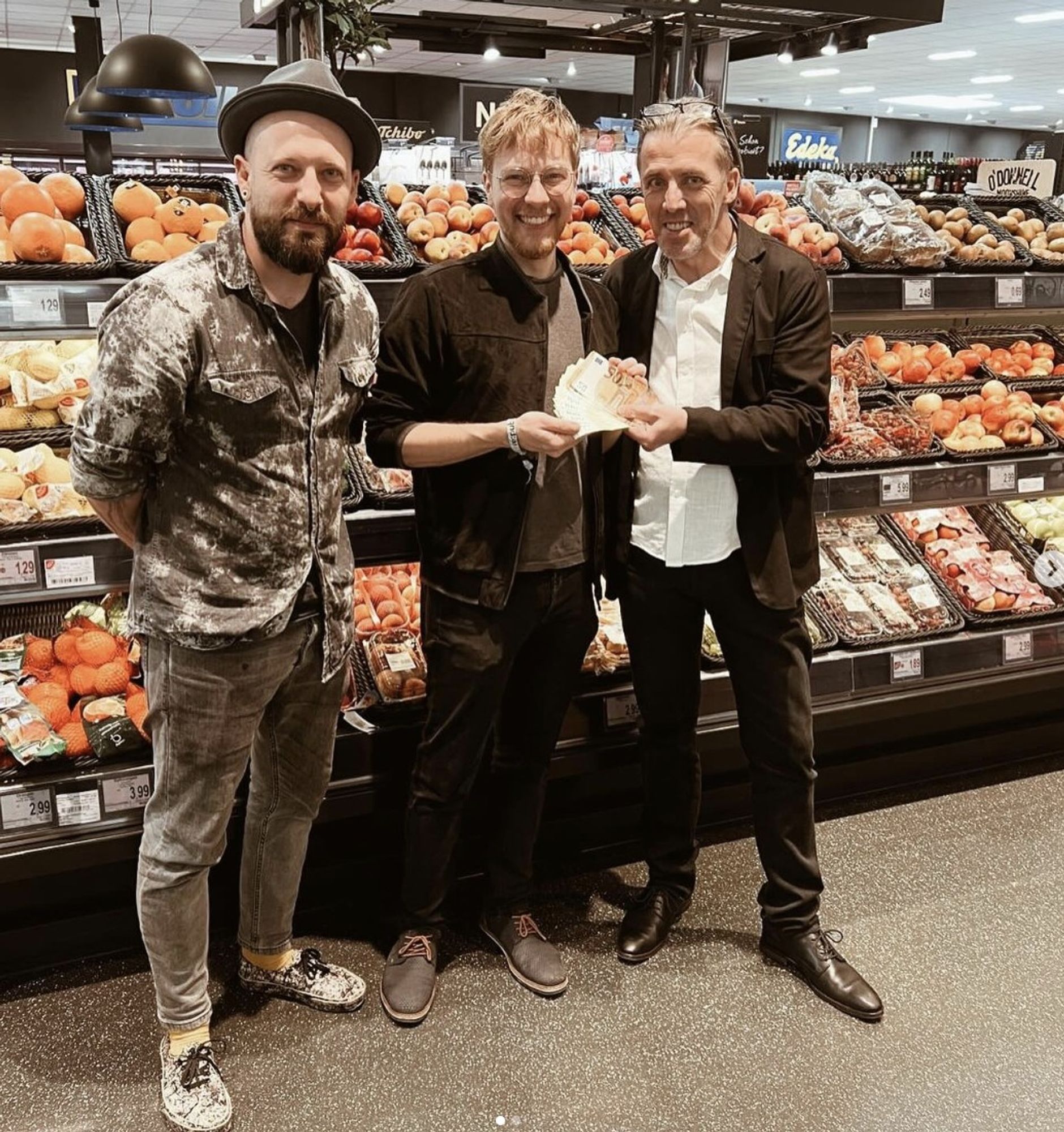 Bild: Ein Mitglied von Aera Tiret (links), in der Mitte Thomas Laschyk von Volksverpetzer, rechts Edeka-Wollny Besitzer, der Thomas 1500€ überreicht in seinem Laden.