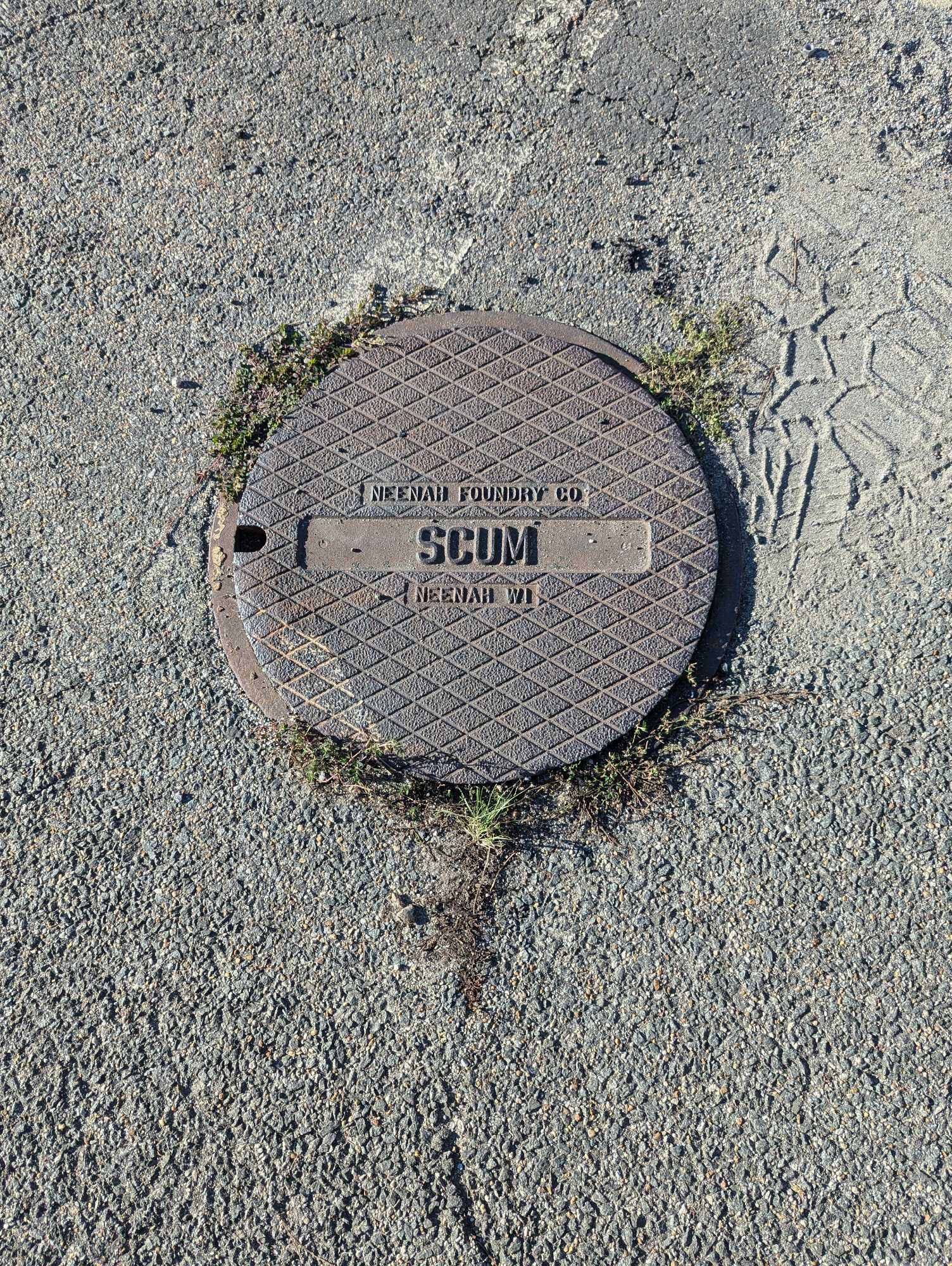 A manhole cover stamped with SCUM