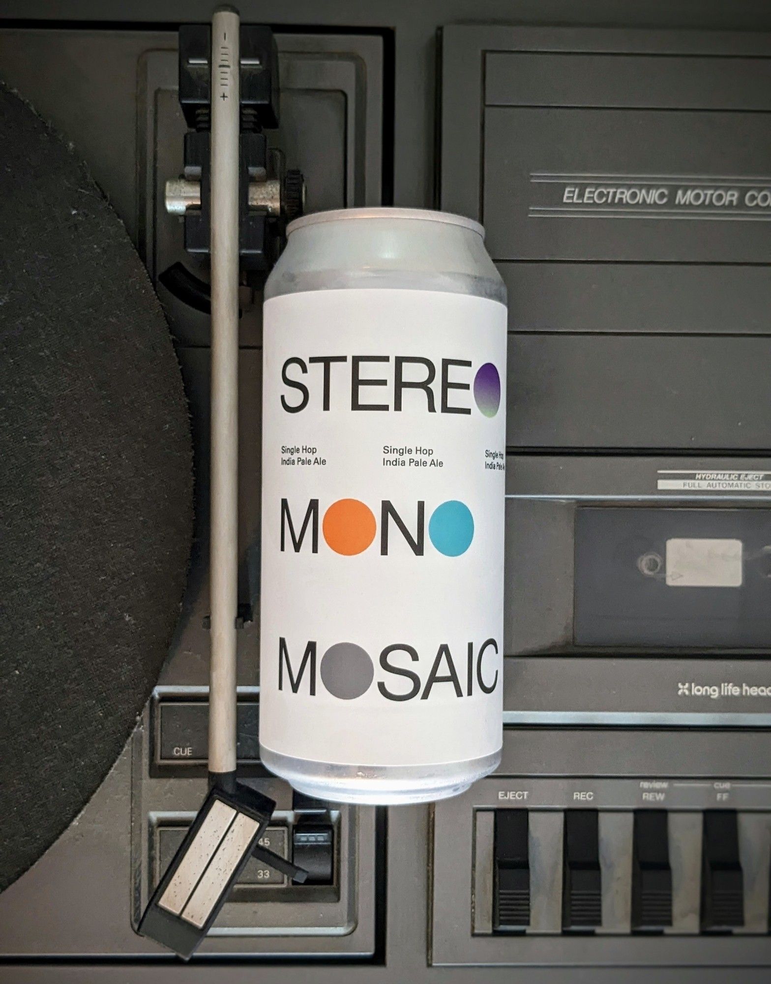 Bierdose Stereo Mono Mosaic IPA von To Øl, die auf einem ca. 1980er Plattenspieler-Tapedeck-Combo liegt.