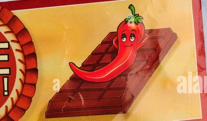 A red chili pepper reclines on a chocolate bar, smiling