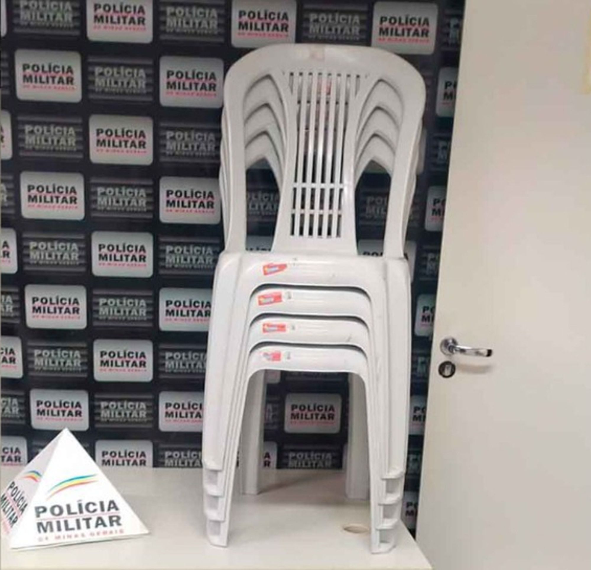 Four stacked plastic chairs on a table at a Minas Gerais police station. DrugBust