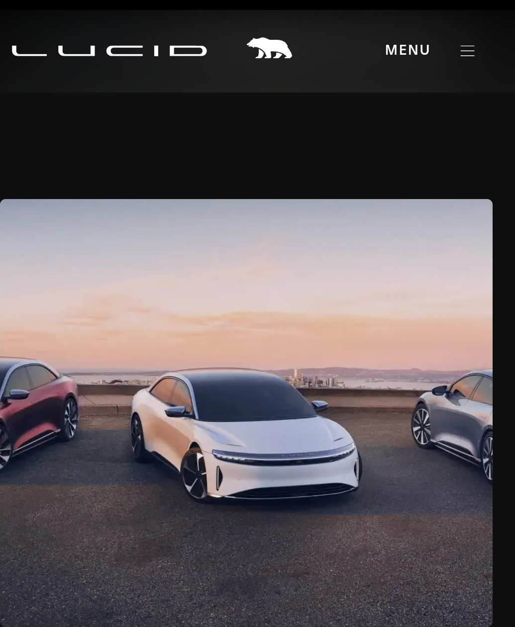 Picture of a white sedan on a road in between two other cars. 