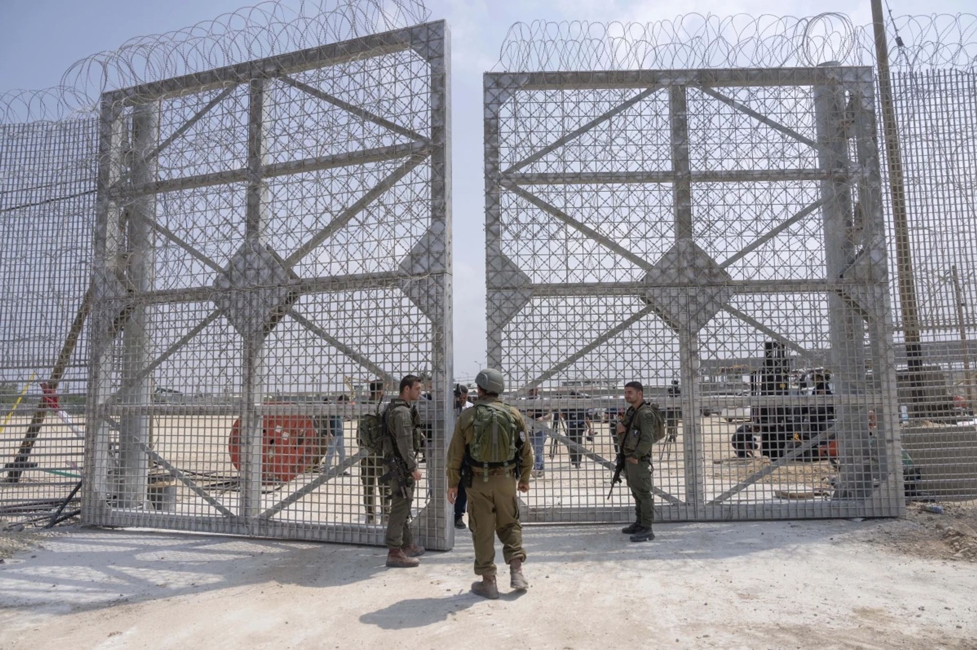 Israeli soldiers gather near a gate to walks through an inspection area for trucks carrying humanitarian aid supplies bound for the Gaza Strip, on the Israeli side of the Erez crossing into northern Gaza, on May 1, 2024. (AP Photo/Ohad Zwigenberg)