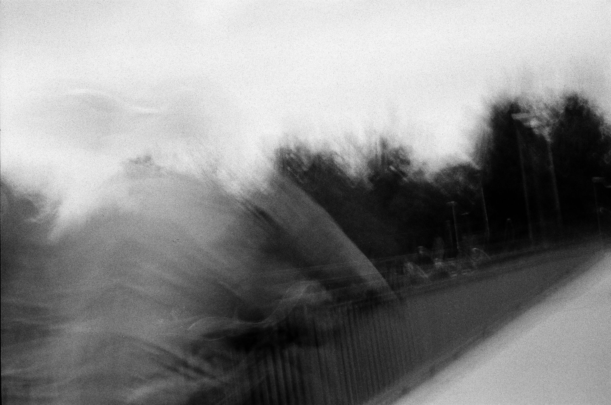 Floating specters sometimes mildly haunting the bridges

a black an white photo of a bridge or walkway with a translucent humanoid shape seemingly floating in from the left