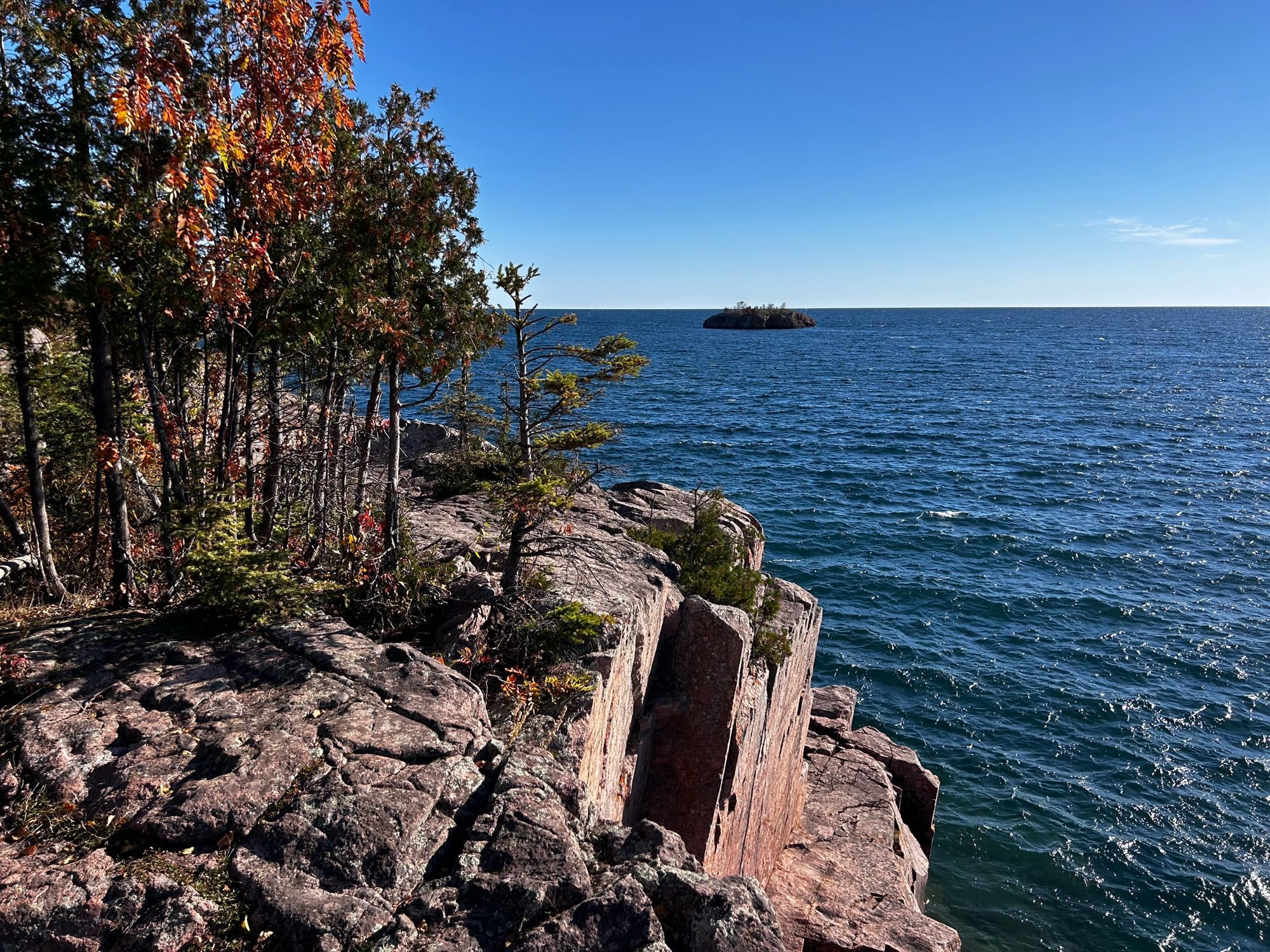 Rocky cliff next to large lake