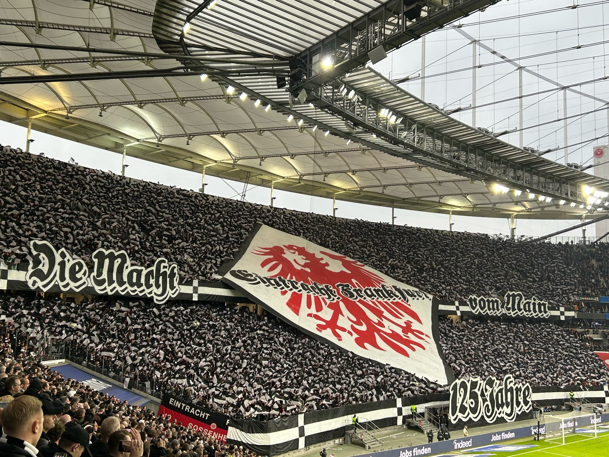 Choreografie in der Nordwestkurve im Waldstadion zum 125 jährigen Bestehen von Eintracht Frankfurt. Logo in der Mitte links und Rechts Spruchband „Die Macht vom Main“