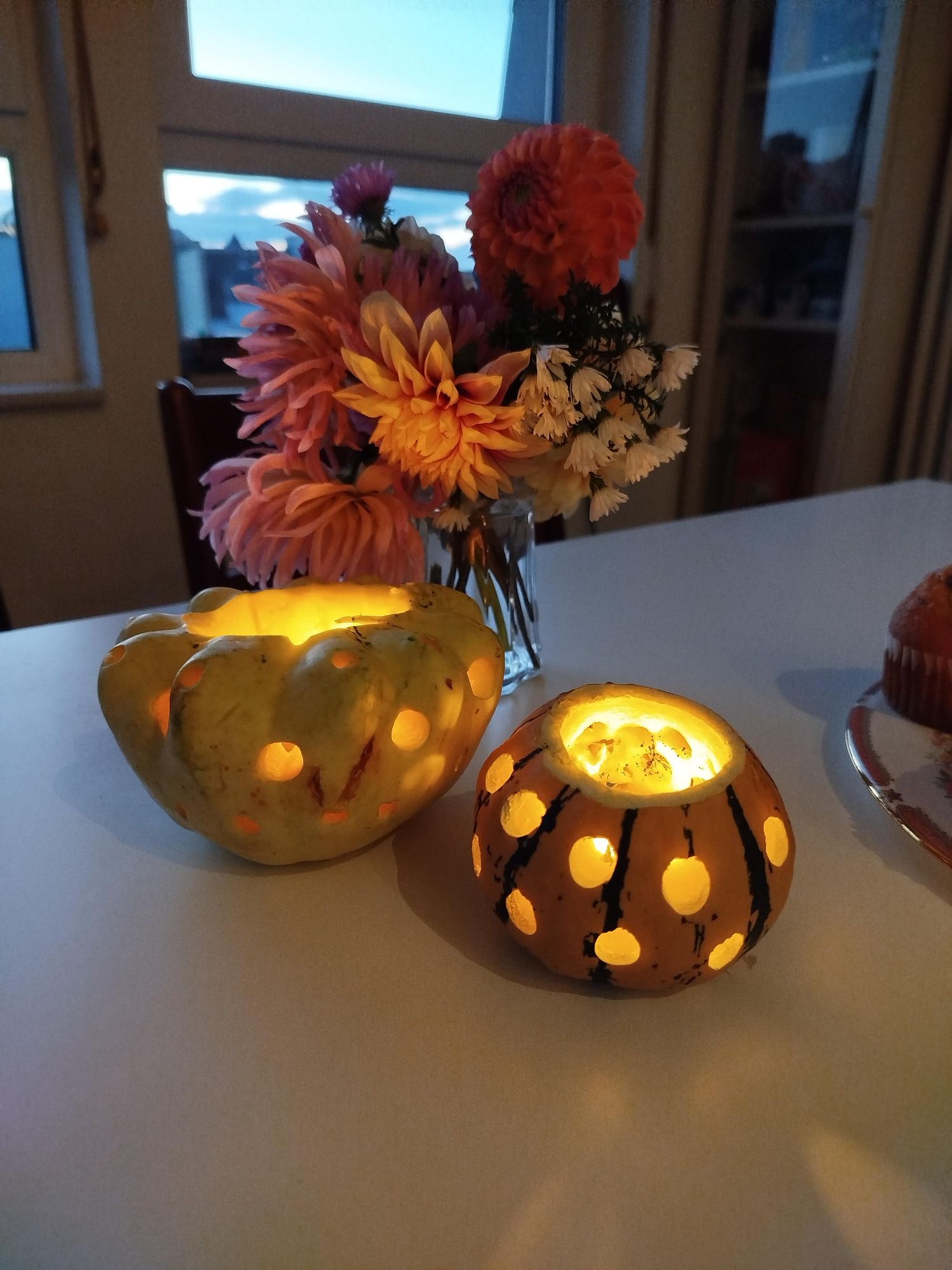 Windlichter aus zierkürbissen mit Löchern drin, Vase mit Dahlien