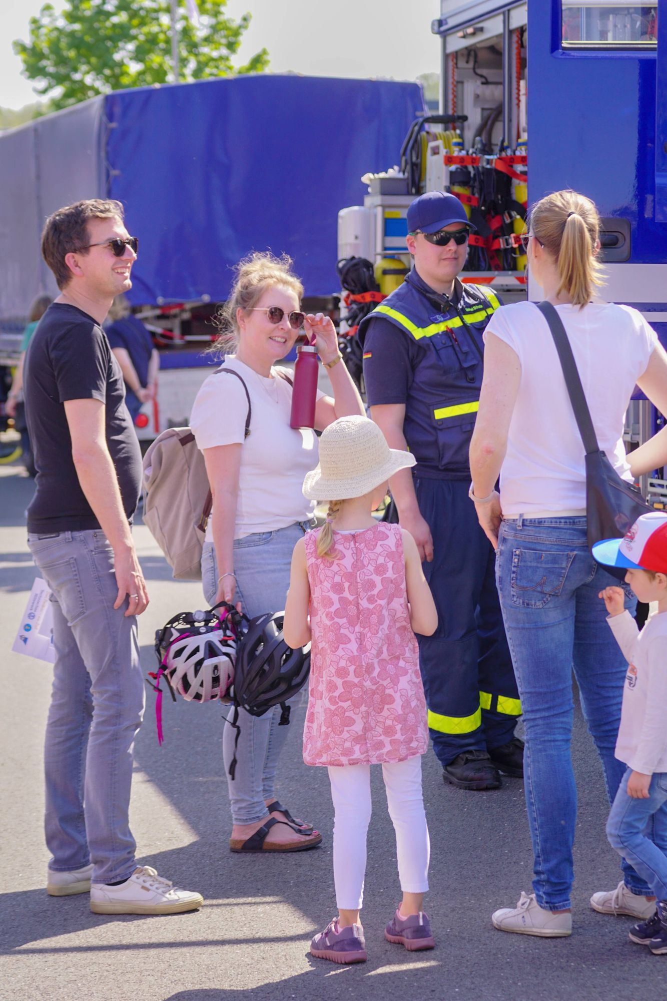 Besucher des Tag der offenen Tür sprechen mit einem THW-Helfer und lassen sich den Gerätekraftwagen der Bergungsgruppe erklären.