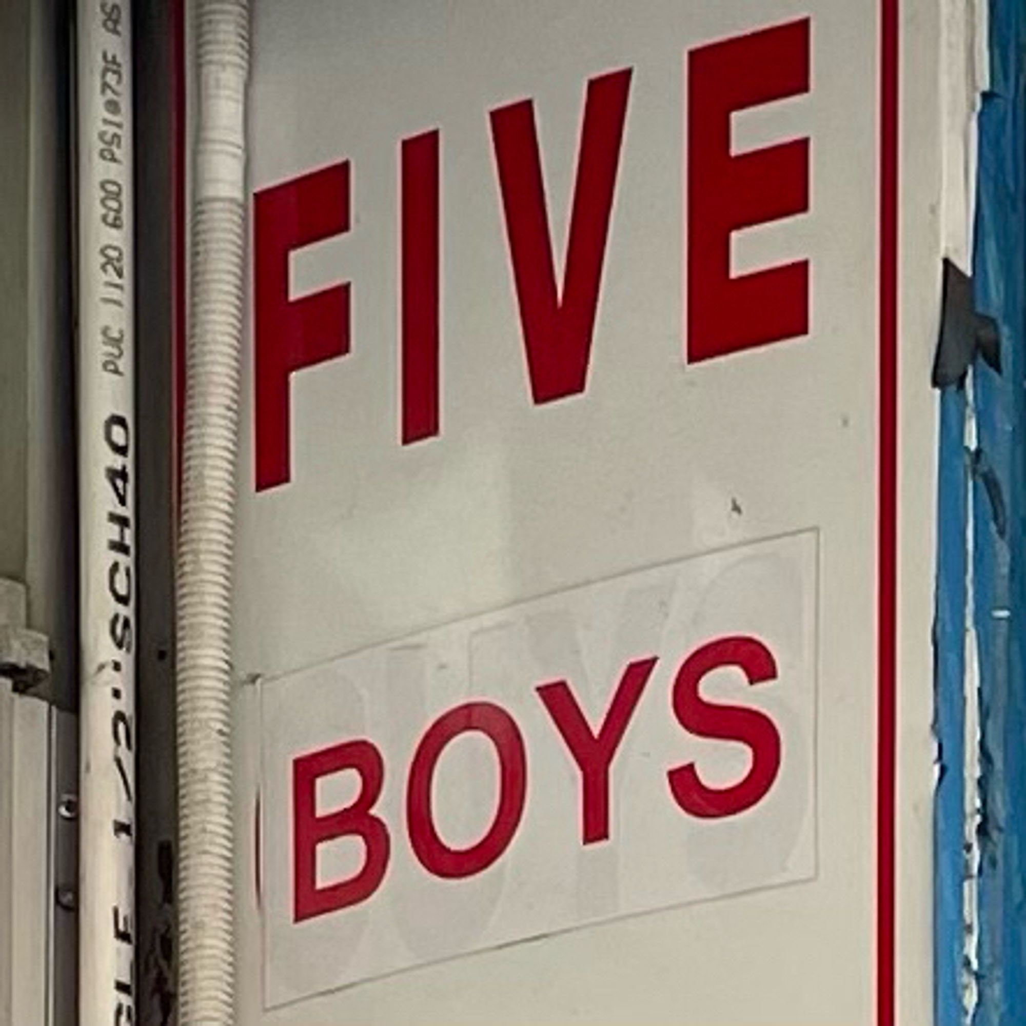 Sign showing that “Boys” was pasted over “Guys”