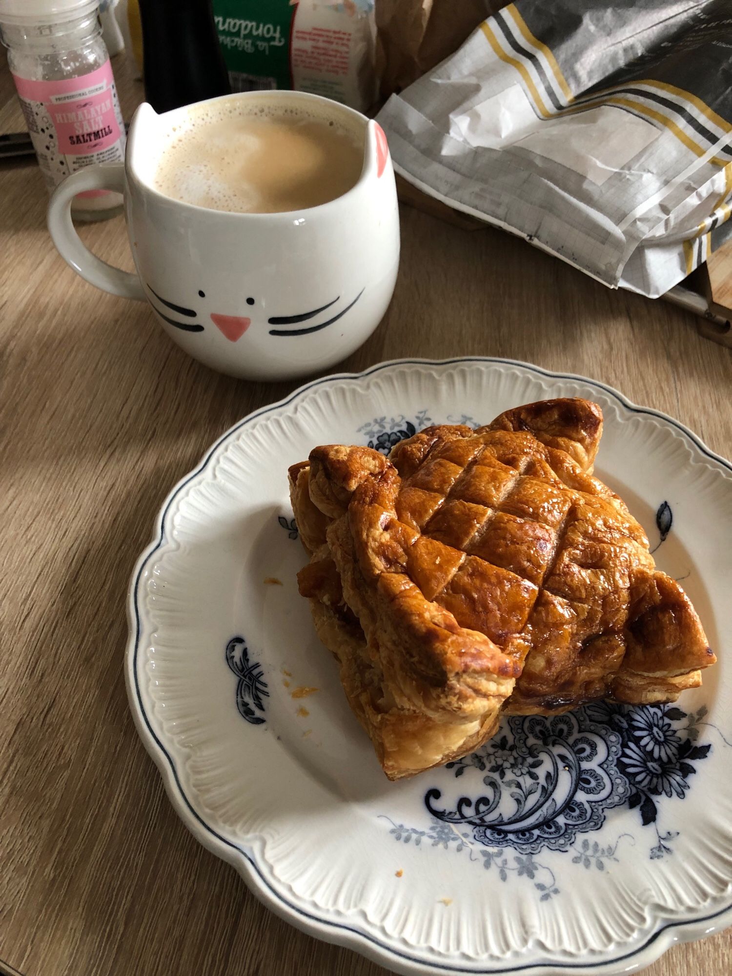 Grand café au lait dans un mug chat, et un chausson aux pommes-cannelle carré.