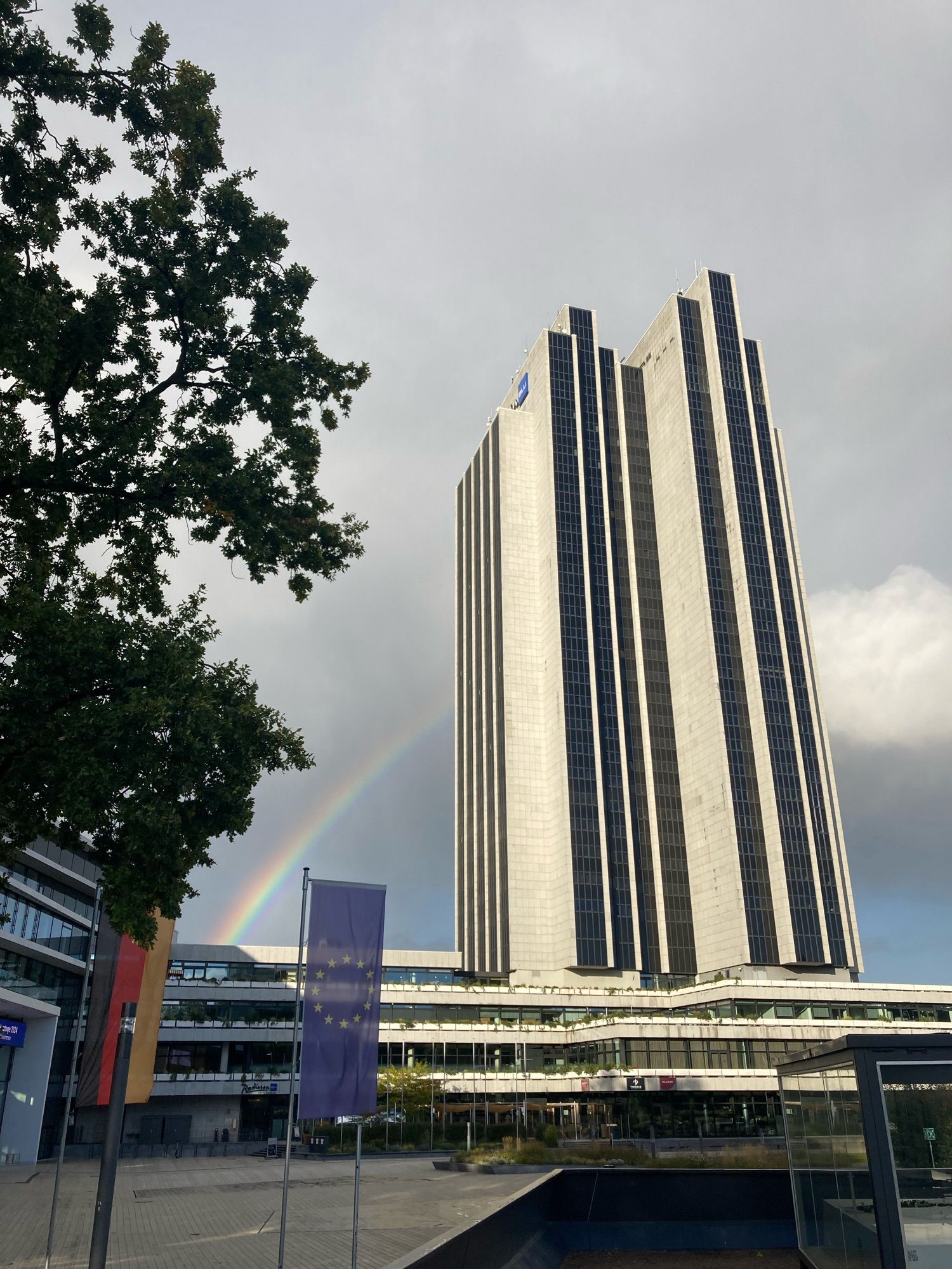 Rainbow disappearing behind a very tall building