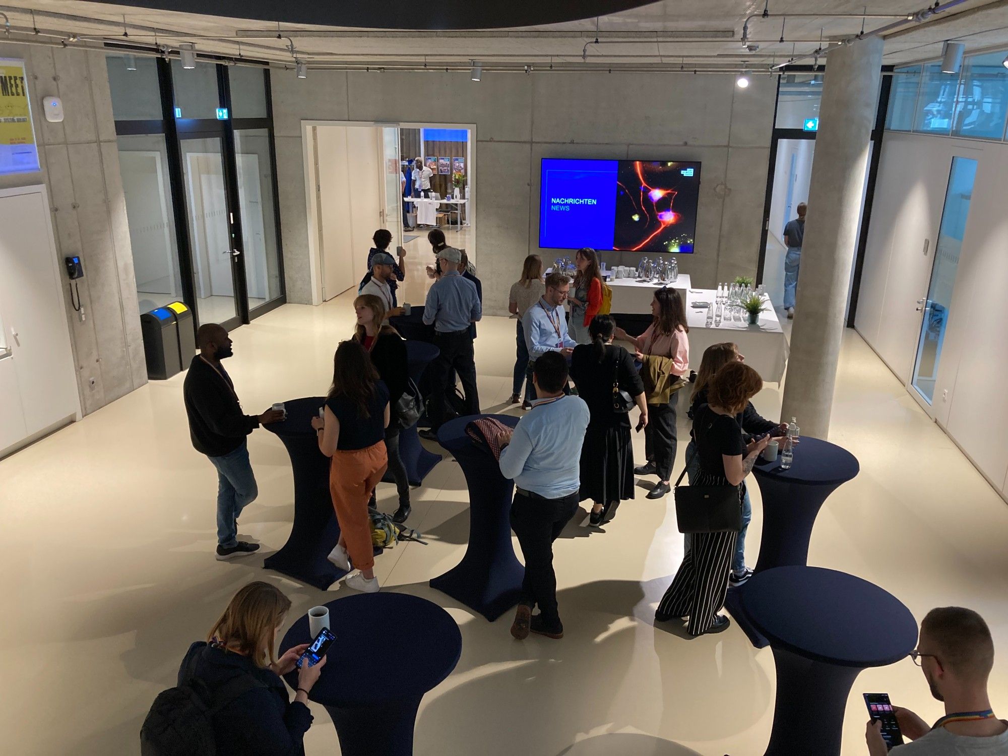 Groups of people conversing in the MDC-BIMSB foyer.